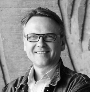 Kim Dambæk - Leikstjóri Føddur í Keypmannahavn í 1957. Sum barn hevur hann búð í Argentina, Uruguay, Malaysia og Onglandi. Varð útbúgving leikstjóri í 1980. Síðani hevur hann arbeitt sum leikstjóri bæði í Danmark, Bretlandi og í øðrum Norðanlondum. Tíðarskeiðið um aldarskiftið var hann lærari í leikstjórn á leiklistaskúlanum í Keypmannahavn. Í 2011 var hann í Føroyum og leikstjórnaði leikin ‘Reinsan’ eftir Sofi Oksanen. 