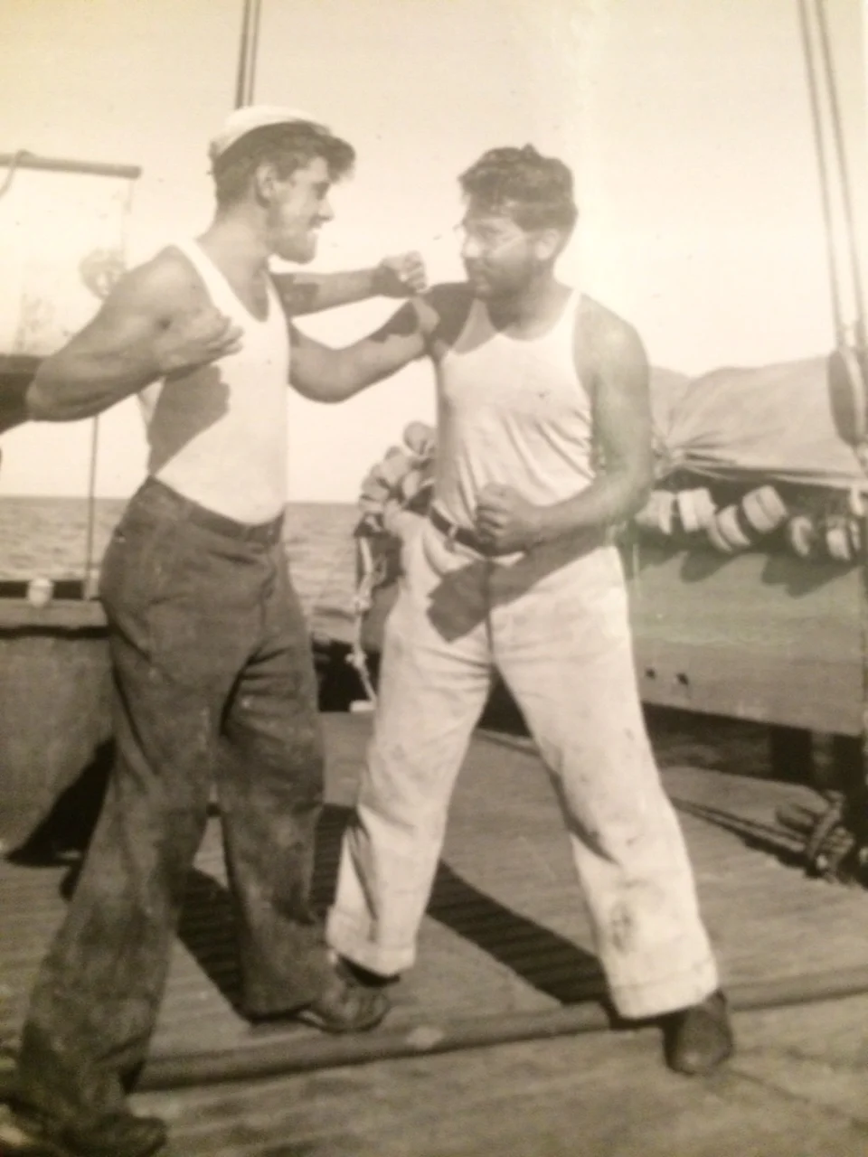 My grandfather on the right, on a fishing boat&nbsp;with a cousin. Possibly taking revenge for the eye?