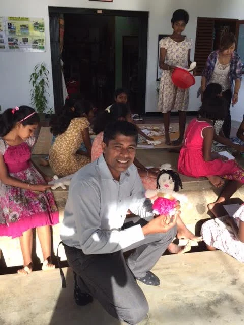 Mr. Eshantha Arlyadasa holding a doll made by Betty