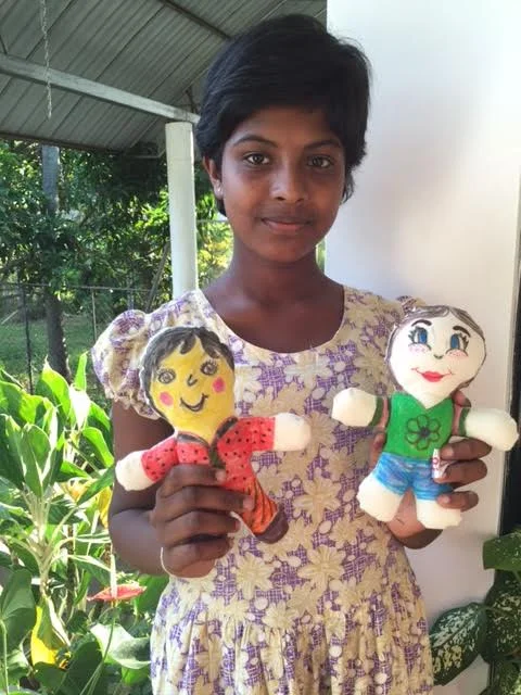 Shanika at Sputnik holding her doll with Maggie's doll 