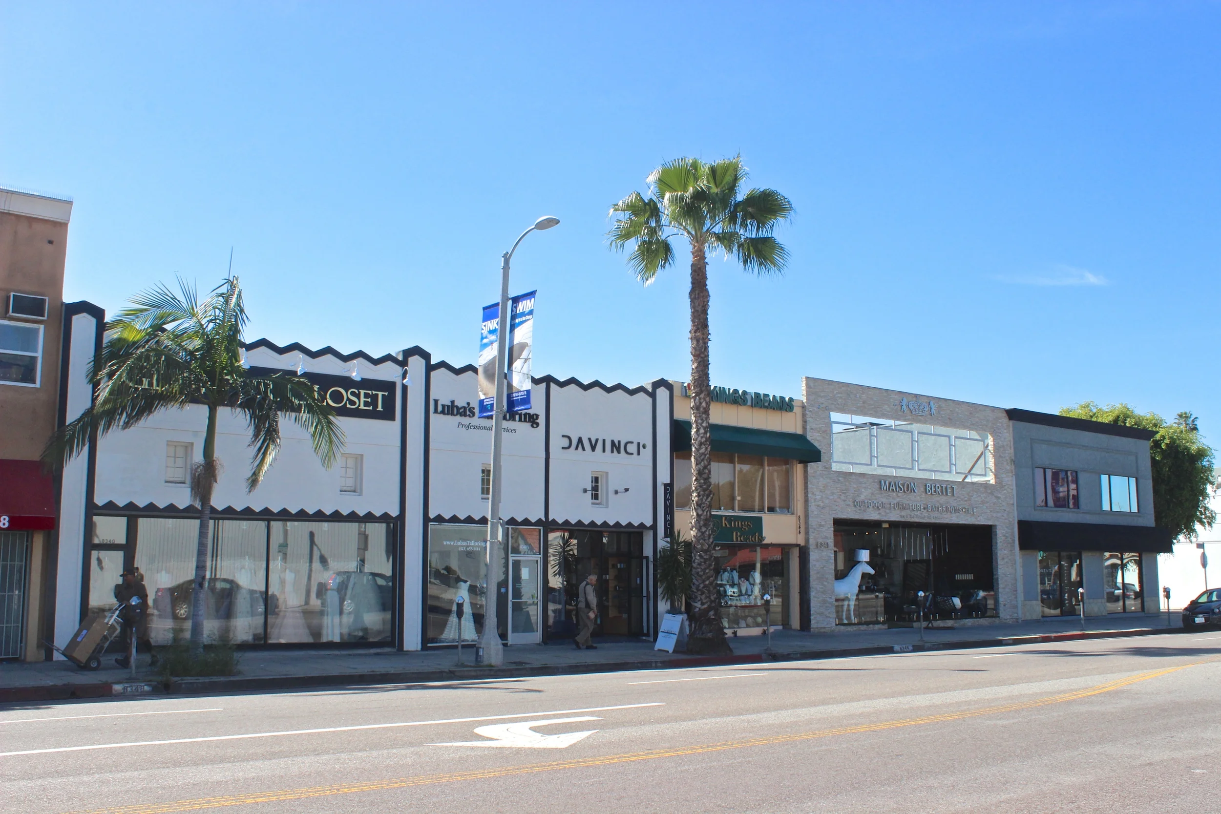 Row of shops on city street  with metered street parking.