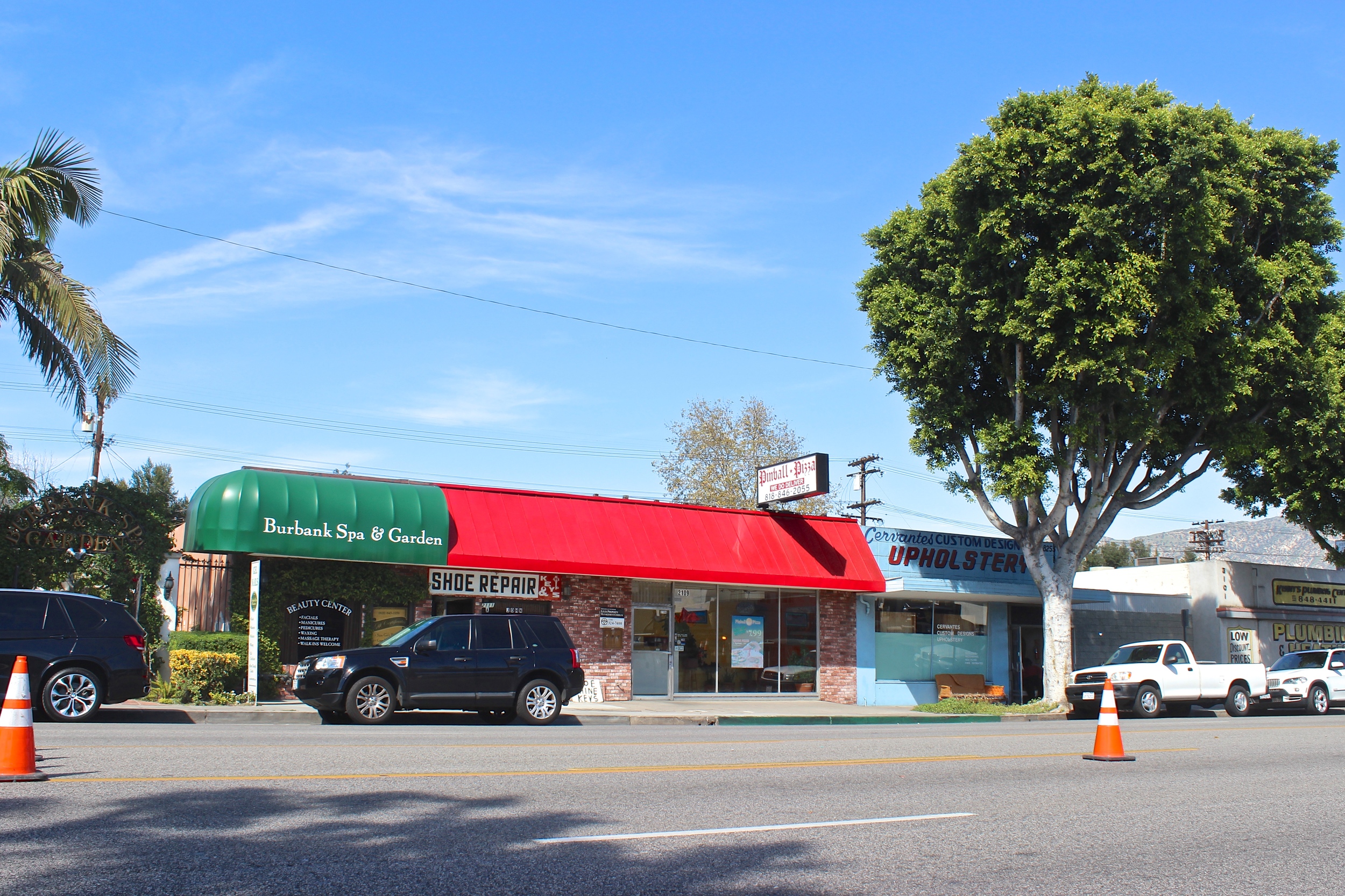 Row of  shops with green and red awning over the storefronts. 