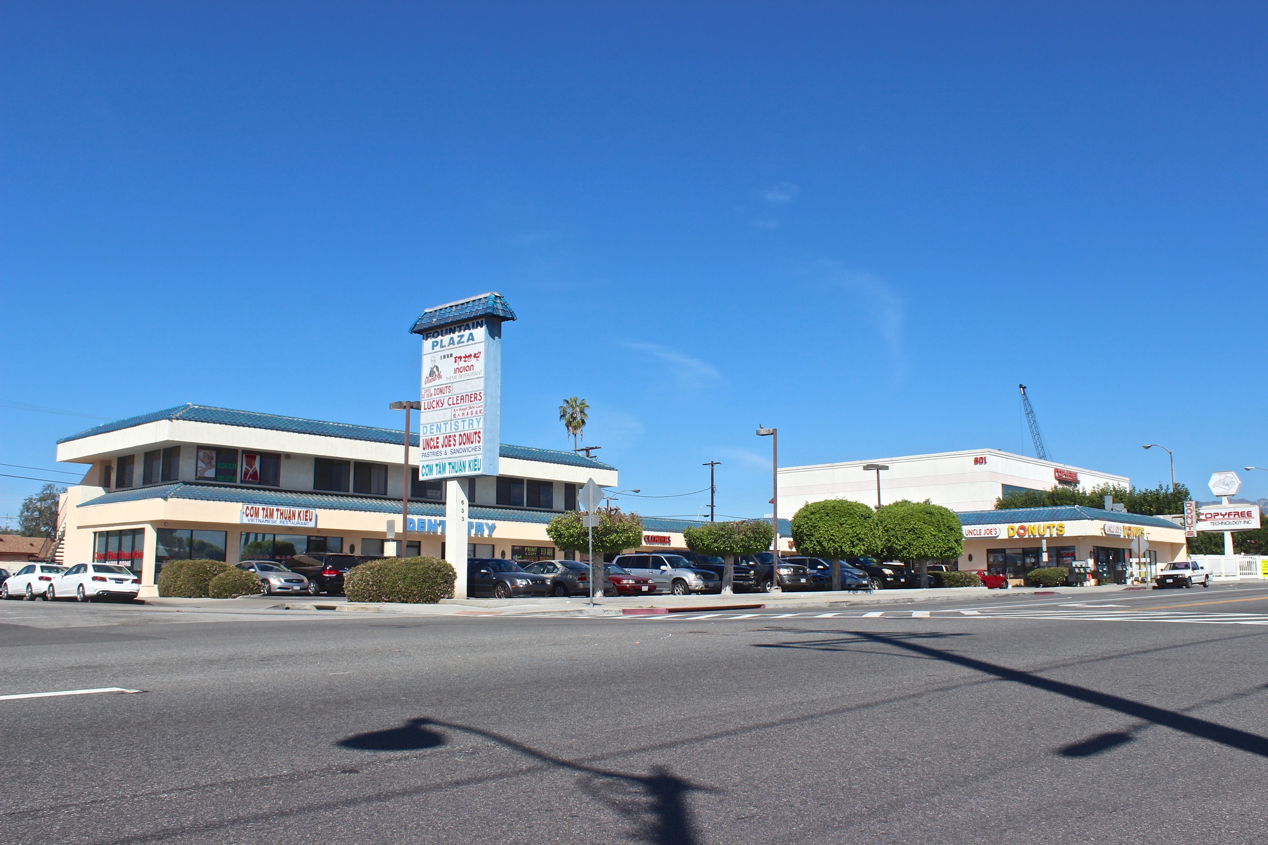  Street view of two story shopping center with multiple store fronts. 