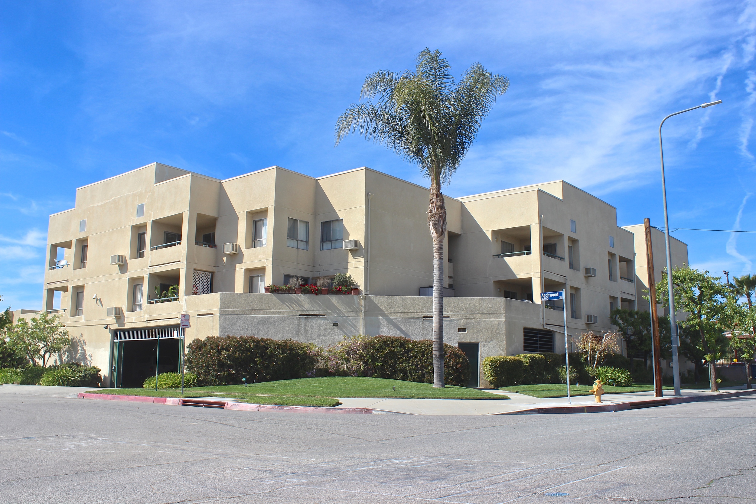 Modern white apartment building with garage underneath.