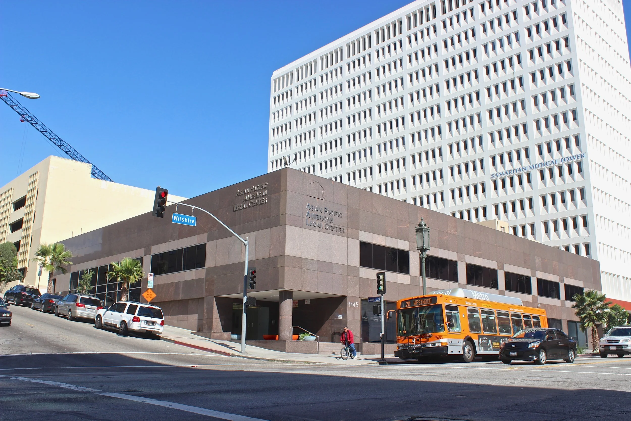 Two story brown building on a corner lot of the Asian Pacific American Legal Center on a busy city street.