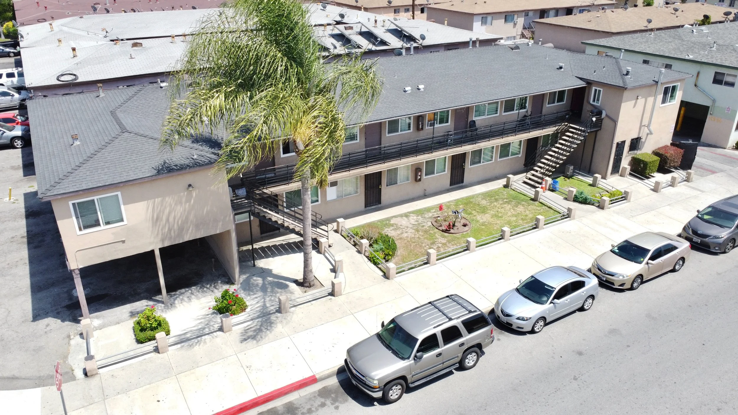 Birds eye view of off white apartment building with stairs leading up to the second floor on either side of the building.