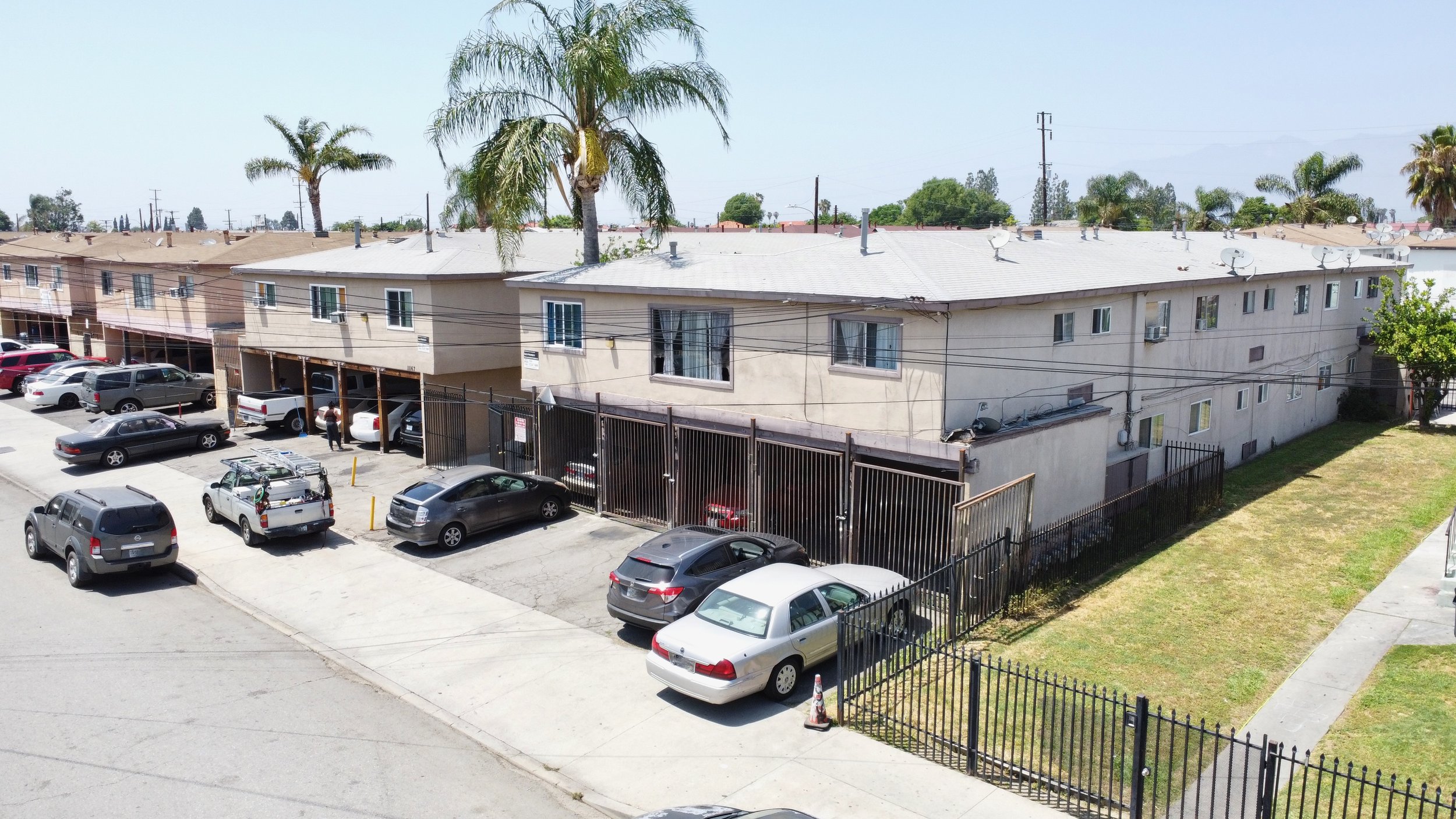  Two story white apartment building with gated car ports.