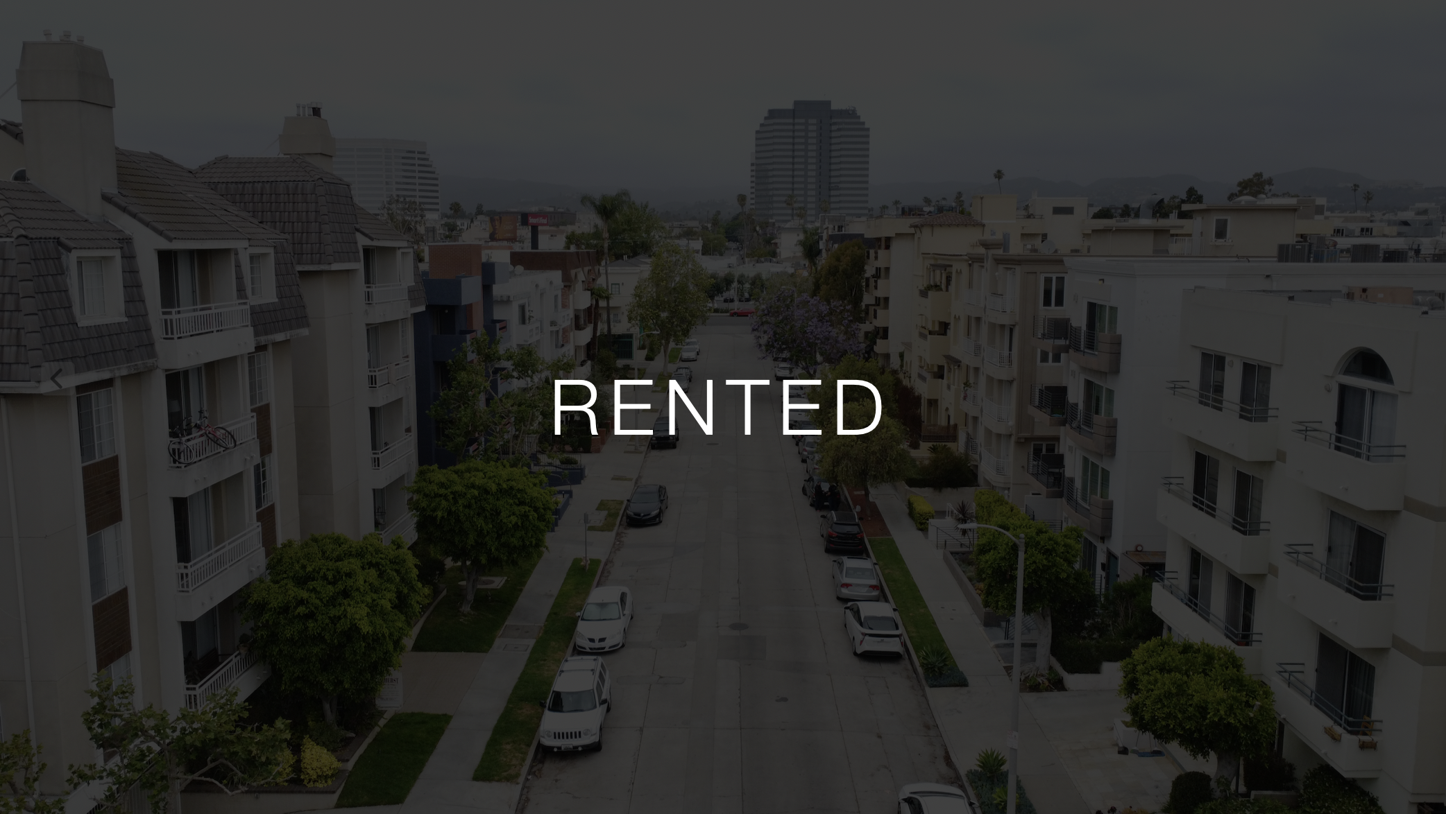 Grayed out street with apartment buildings on either side with text saying Rented.