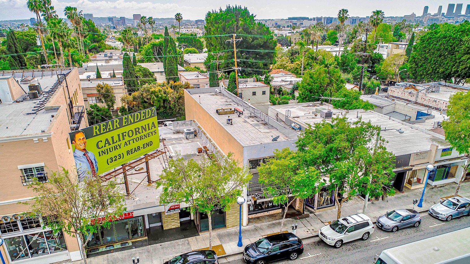 Elevated view of a commercial street with a large attorney billboard 2