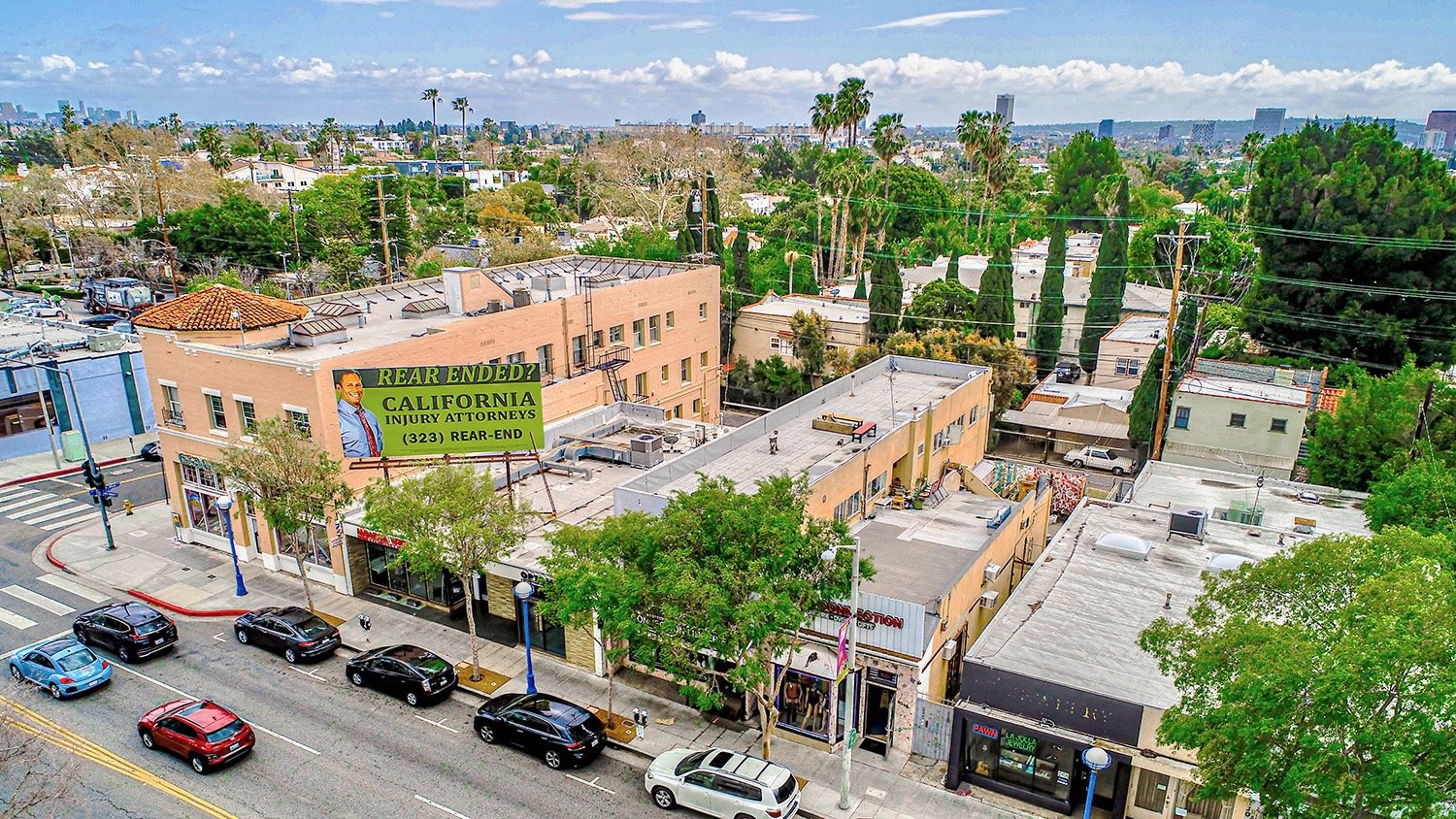 Elevated view of a commercial street with a large attorney billboard 3