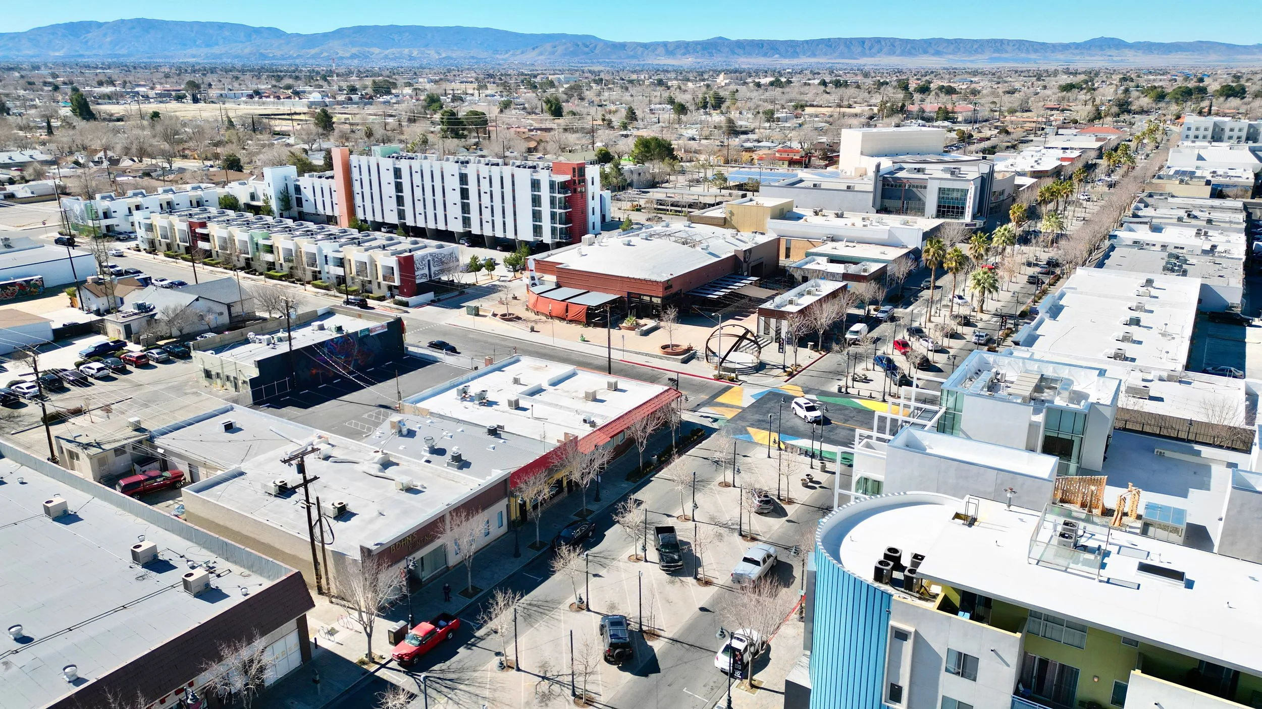 Bird's-eye view of a town with diverse architecture, streets, and a mountain backdrop.