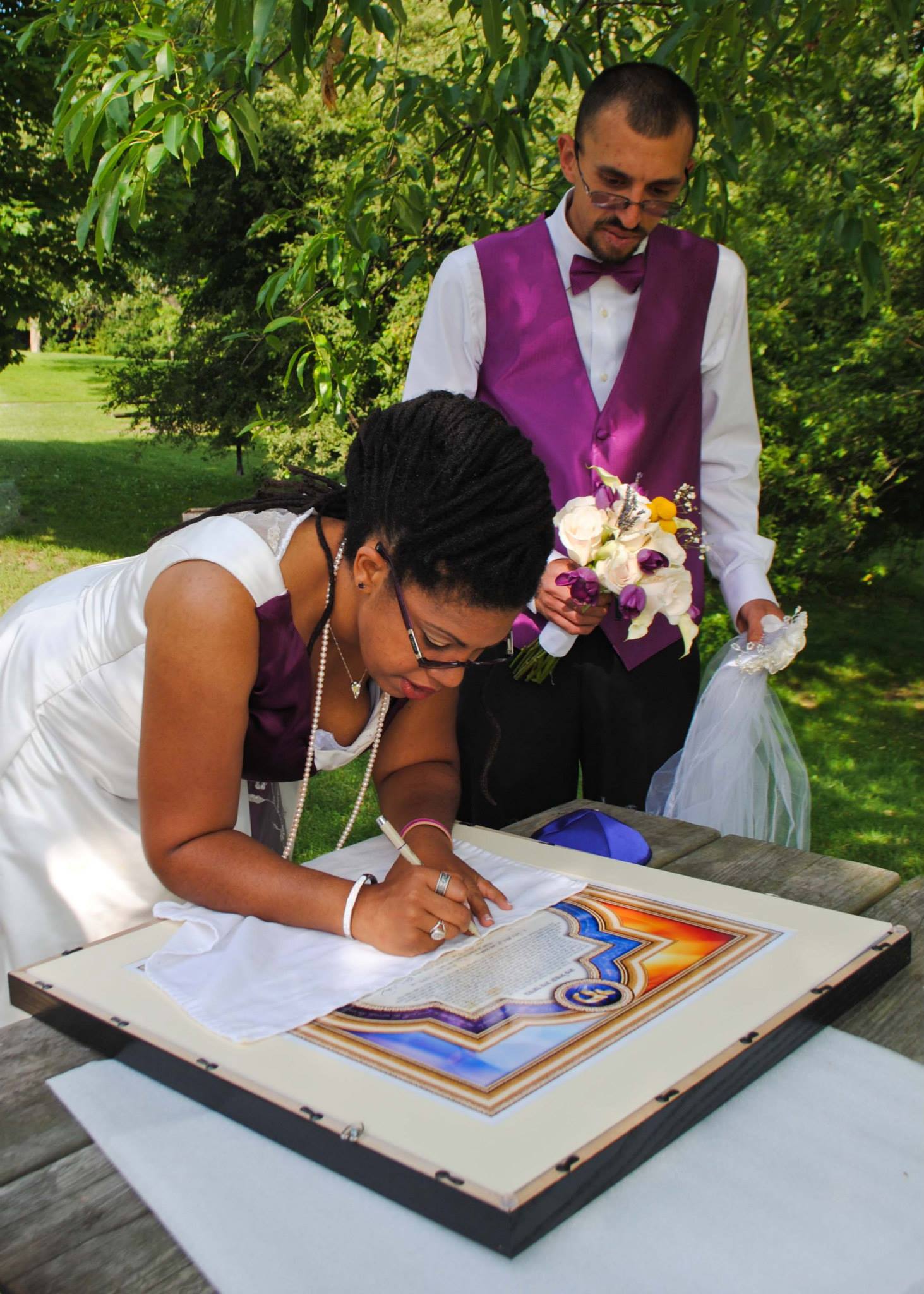  Couple signing Jewish marriage document at wedding 