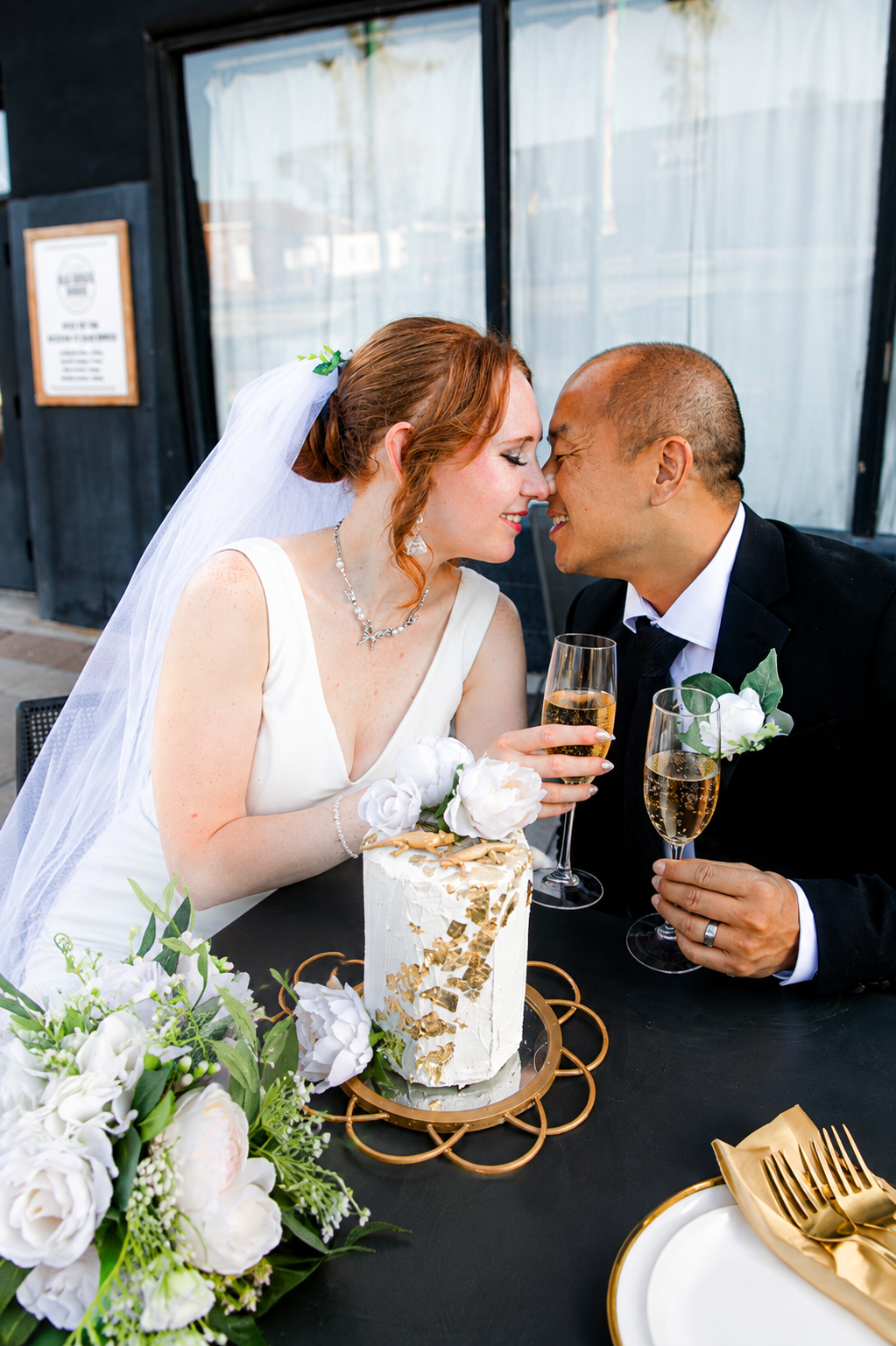Rana and Nick during their intimate elopement in Mesa, Arizona, photographed by TallulahMade Photography. This romantic wedding portrait captures the couple celebrating their marriage against the warm desert architecture of Mesa, blending candid conn
