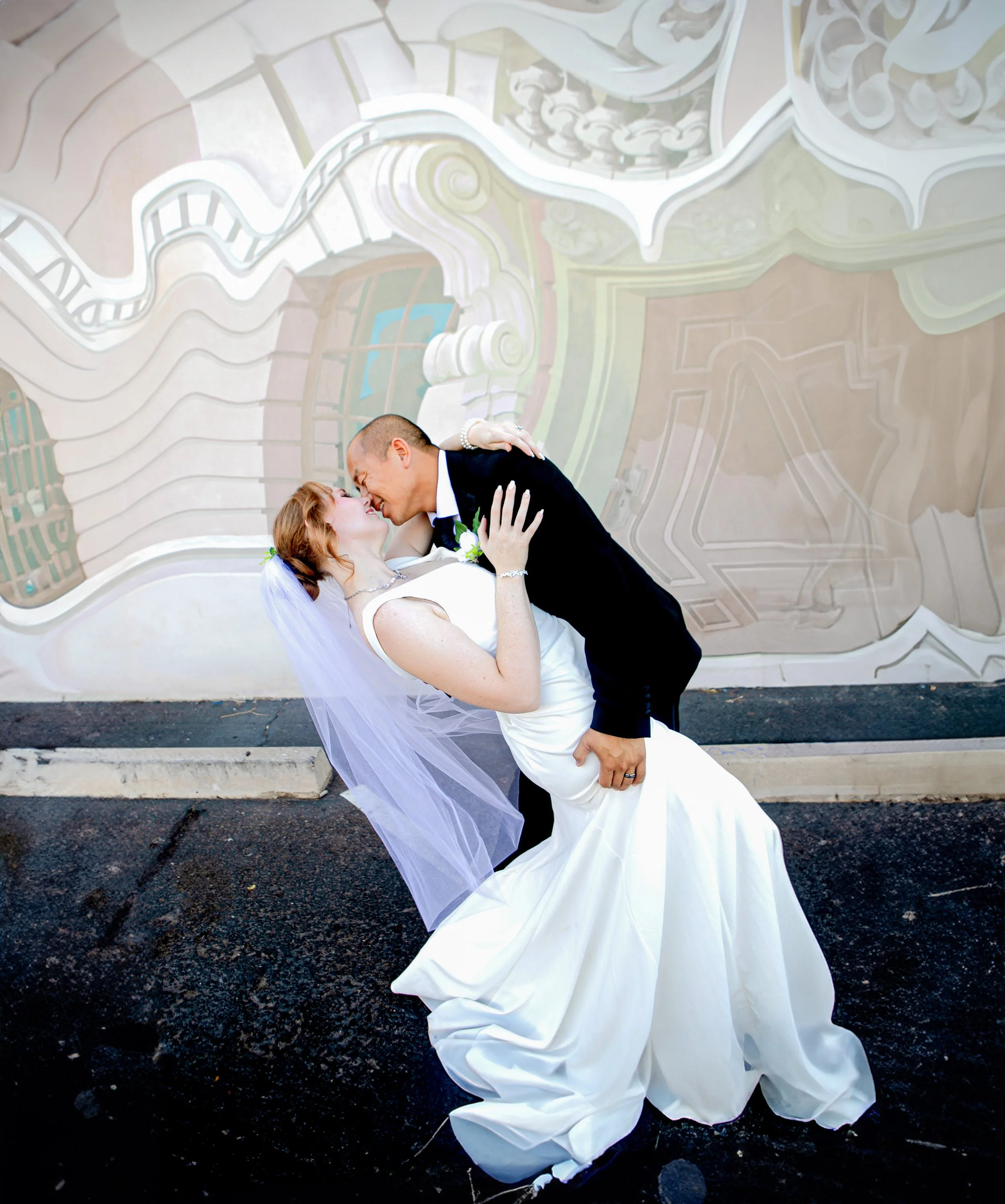 Rana and Nick during their intimate elopement in Mesa, Arizona, photographed by TallulahMade Photography. This romantic wedding portrait captures the couple celebrating their marriage against the warm desert architecture of Mesa, blending candid conn