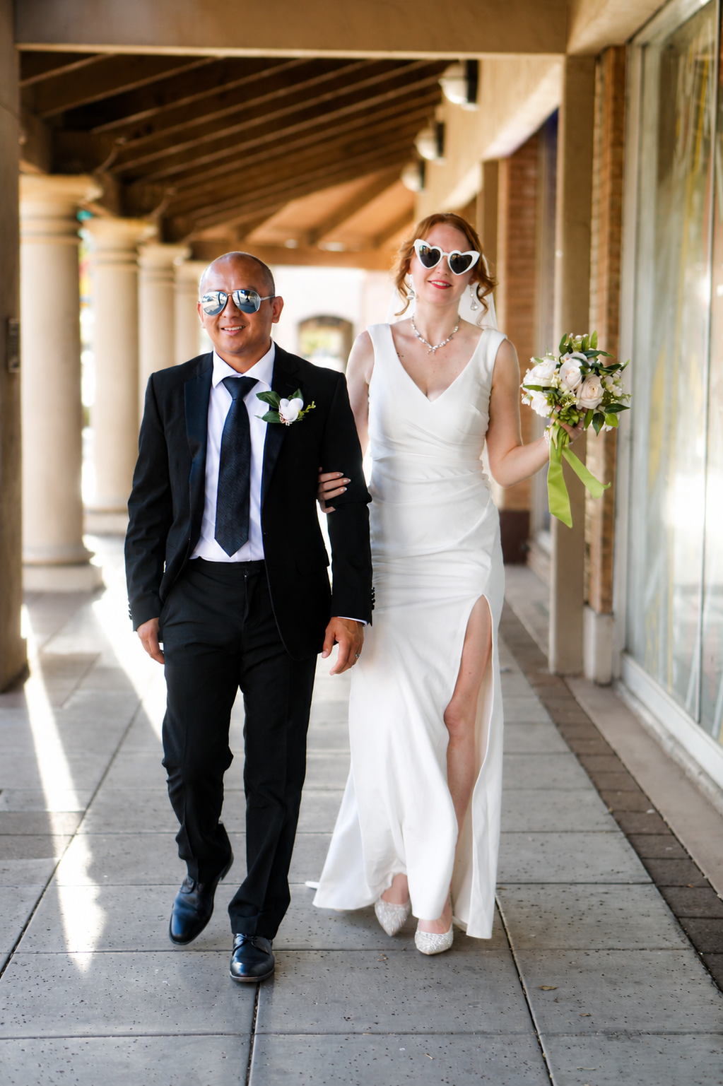 Rana and Nick during their intimate elopement in Mesa, Arizona, photographed by TallulahMade Photography. This romantic wedding portrait captures the couple celebrating their marriage against the warm desert architecture of Mesa, blending candid conn