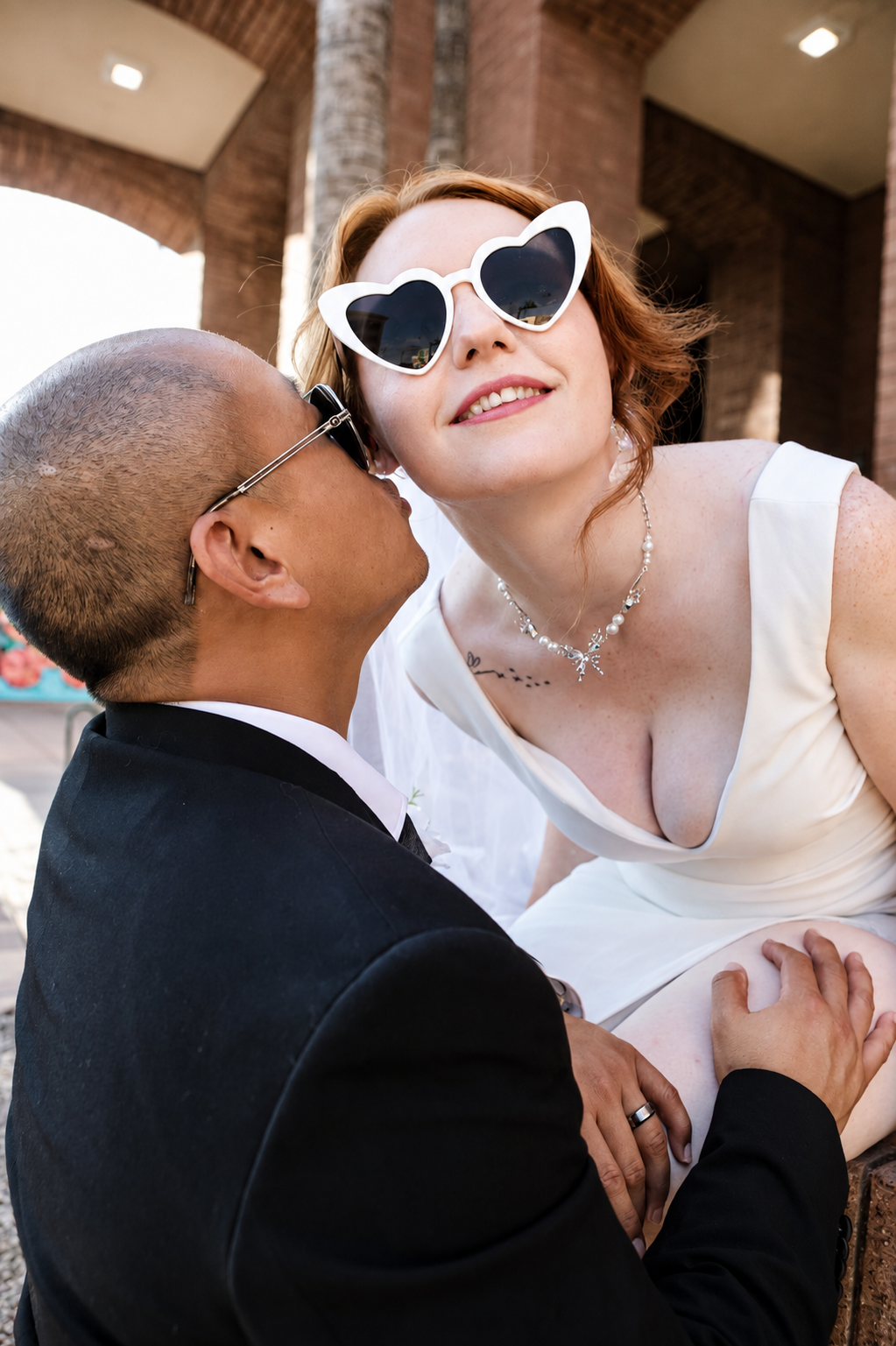 Rana and Nick during their intimate elopement in Mesa, Arizona, photographed by TallulahMade Photography. This romantic wedding portrait captures the couple celebrating their marriage against the warm desert architecture of Mesa, blending candid conn