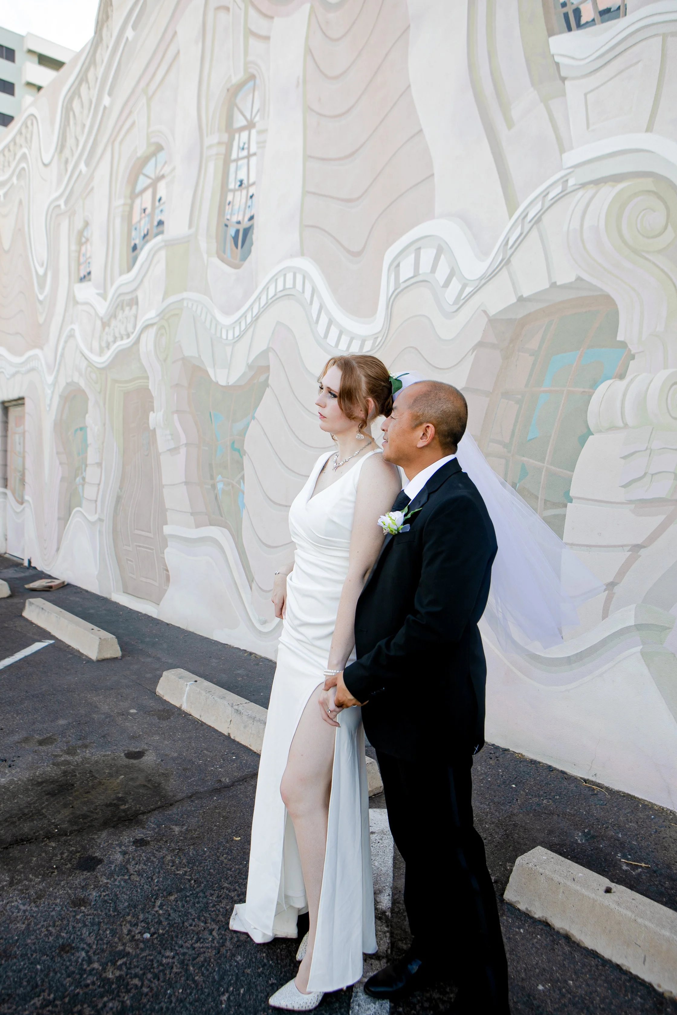 Rana and Nick during their intimate elopement in Mesa, Arizona, photographed by TallulahMade Photography. This romantic wedding portrait captures the couple celebrating their marriage against the warm desert architecture of Mesa, blending candid conn