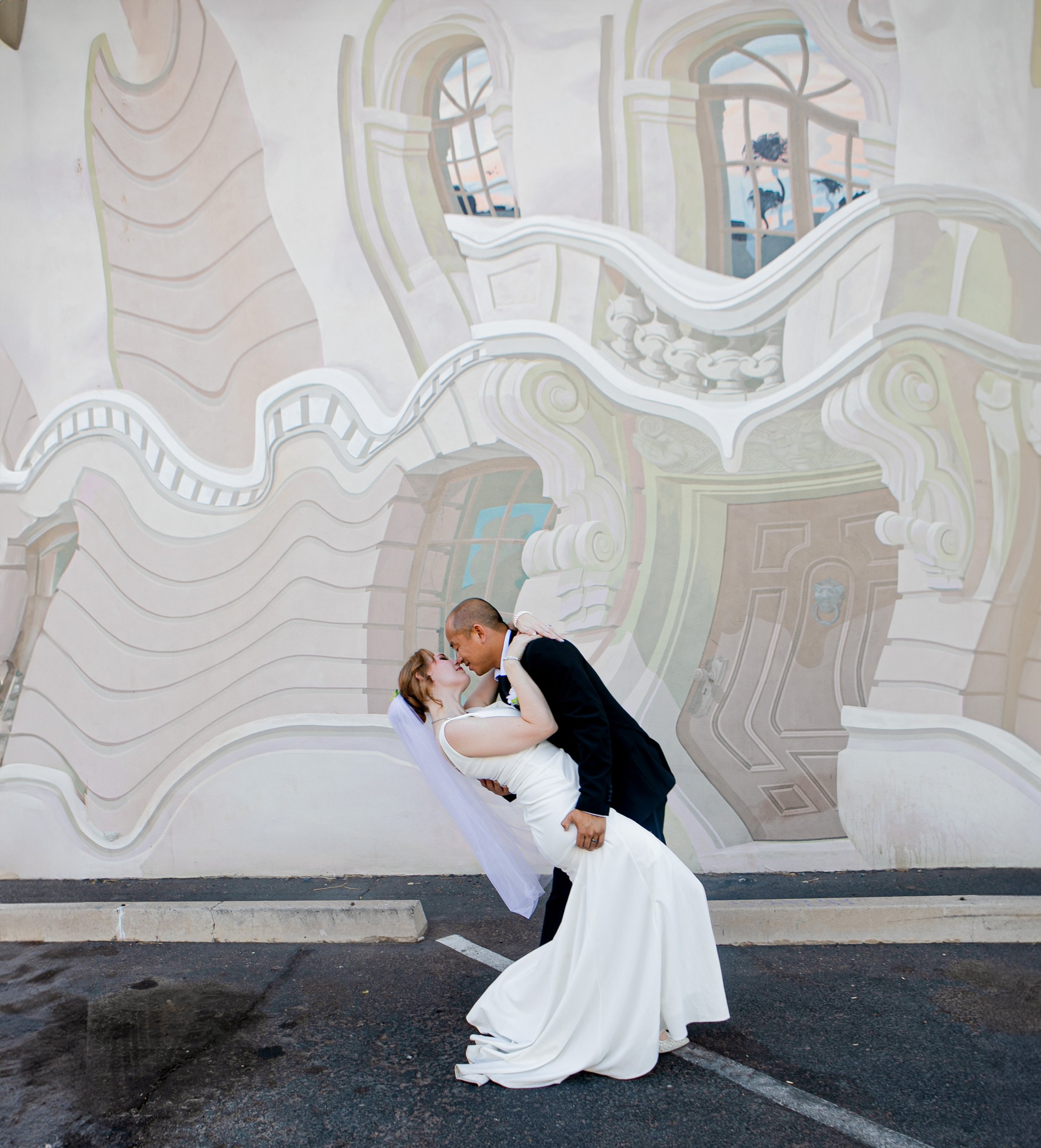 Rana and Nick during their intimate elopement in Mesa, Arizona, photographed by TallulahMade Photography. This romantic wedding portrait captures the couple celebrating their marriage against the warm desert architecture of Mesa, blending candid conn