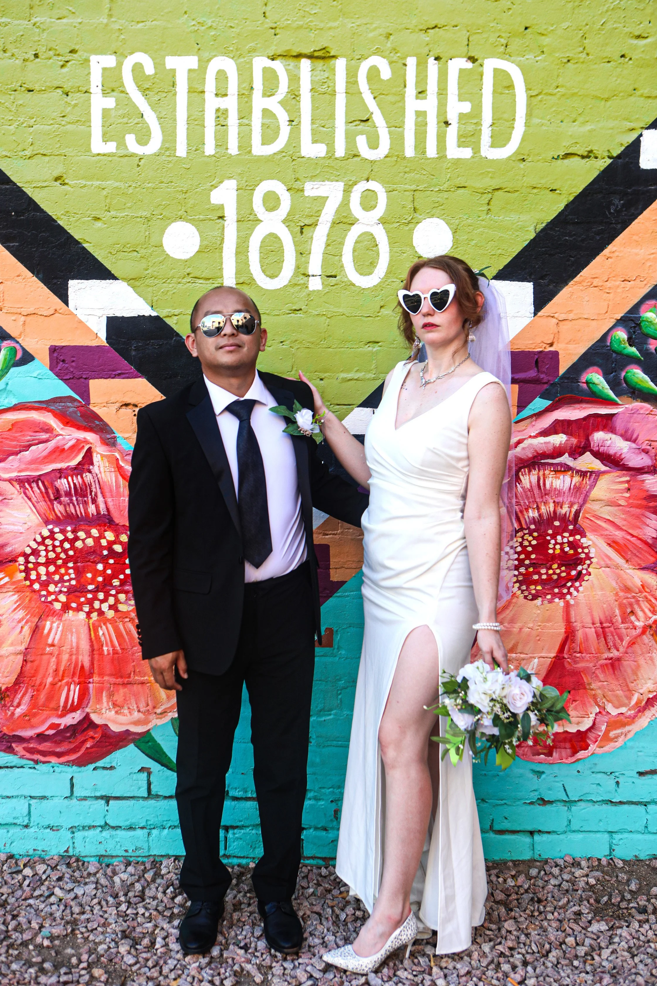 Rana and Nick during their intimate elopement in Mesa, Arizona, photographed by TallulahMade Photography. This romantic wedding portrait captures the couple celebrating their marriage against the warm desert architecture of Mesa, blending candid conn
