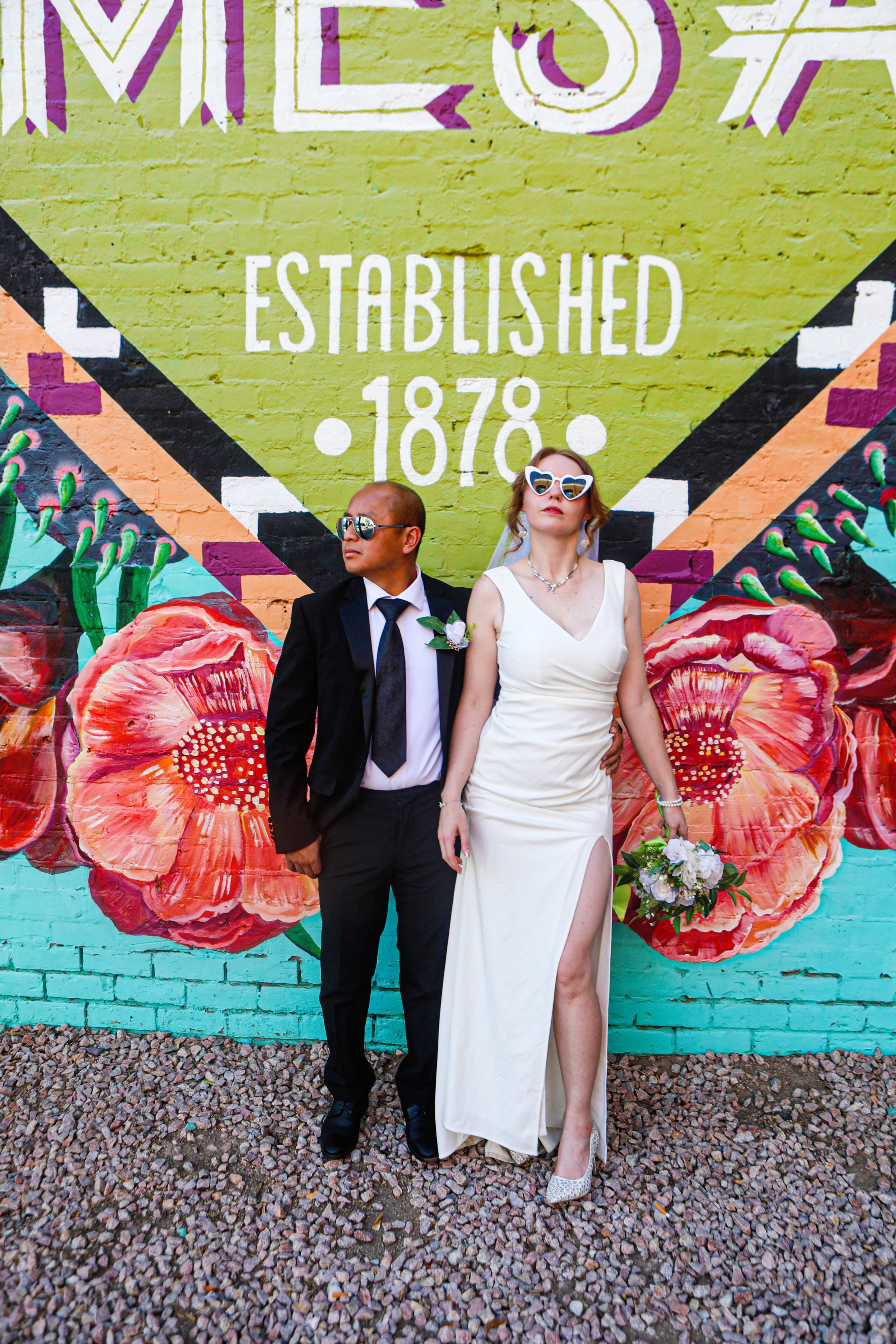 Rana and Nick during their intimate elopement in Mesa, Arizona, photographed by TallulahMade Photography. This romantic wedding portrait captures the couple celebrating their marriage against the warm desert architecture of Mesa, blending candid conn