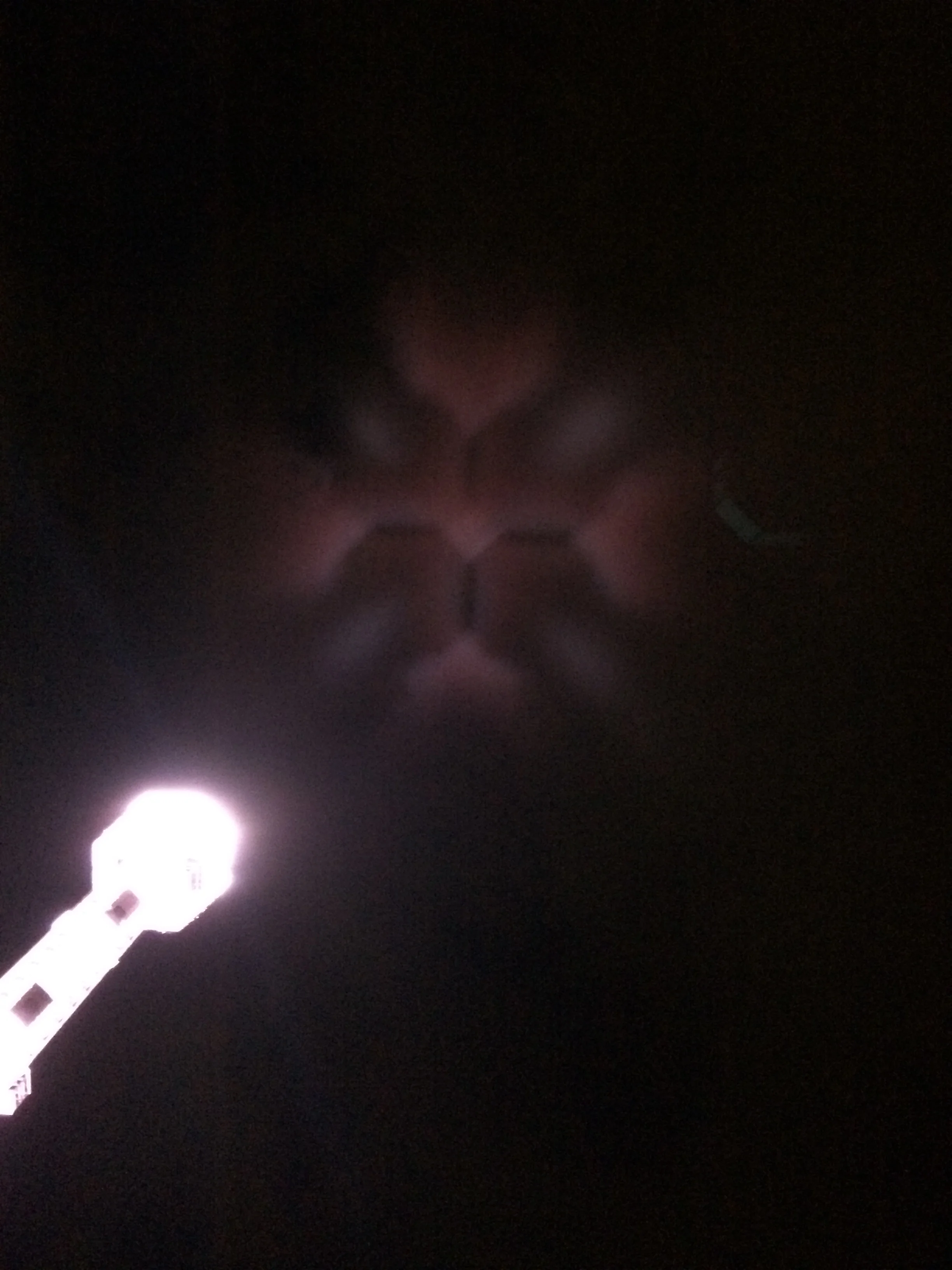 The tower lighting is so bright that they cast a shadow of the tower on the clouds in the night sky
