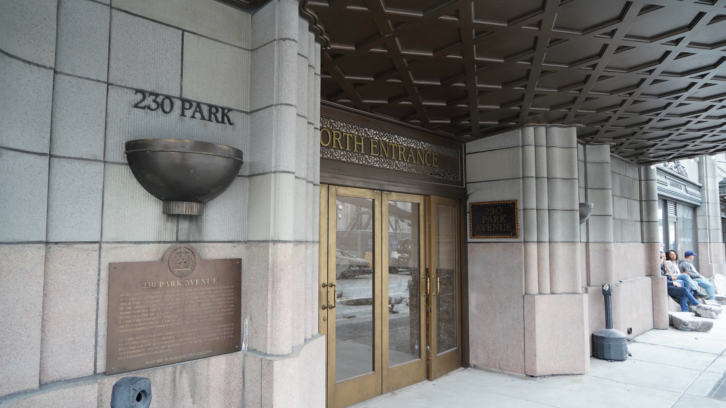 Entrance to a building at 230 Park Avenue with a sign indicating 'North Entrance.'