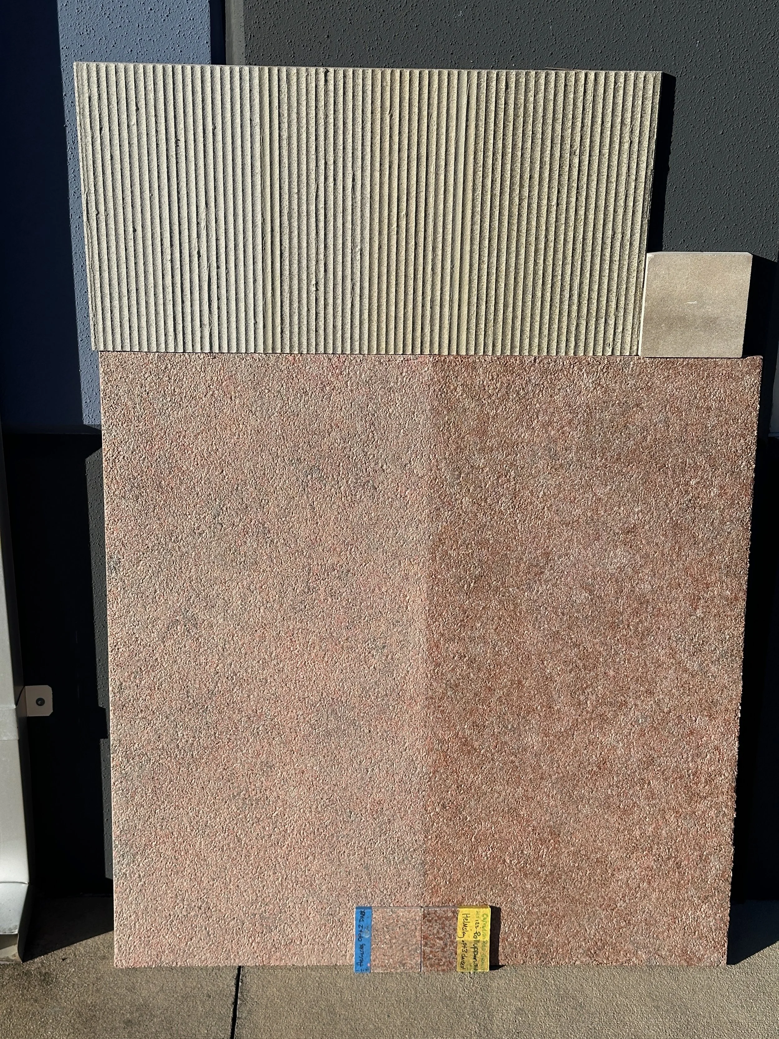 Collection of three different textured tile samples on display, with a small color and label guide at the bottom
