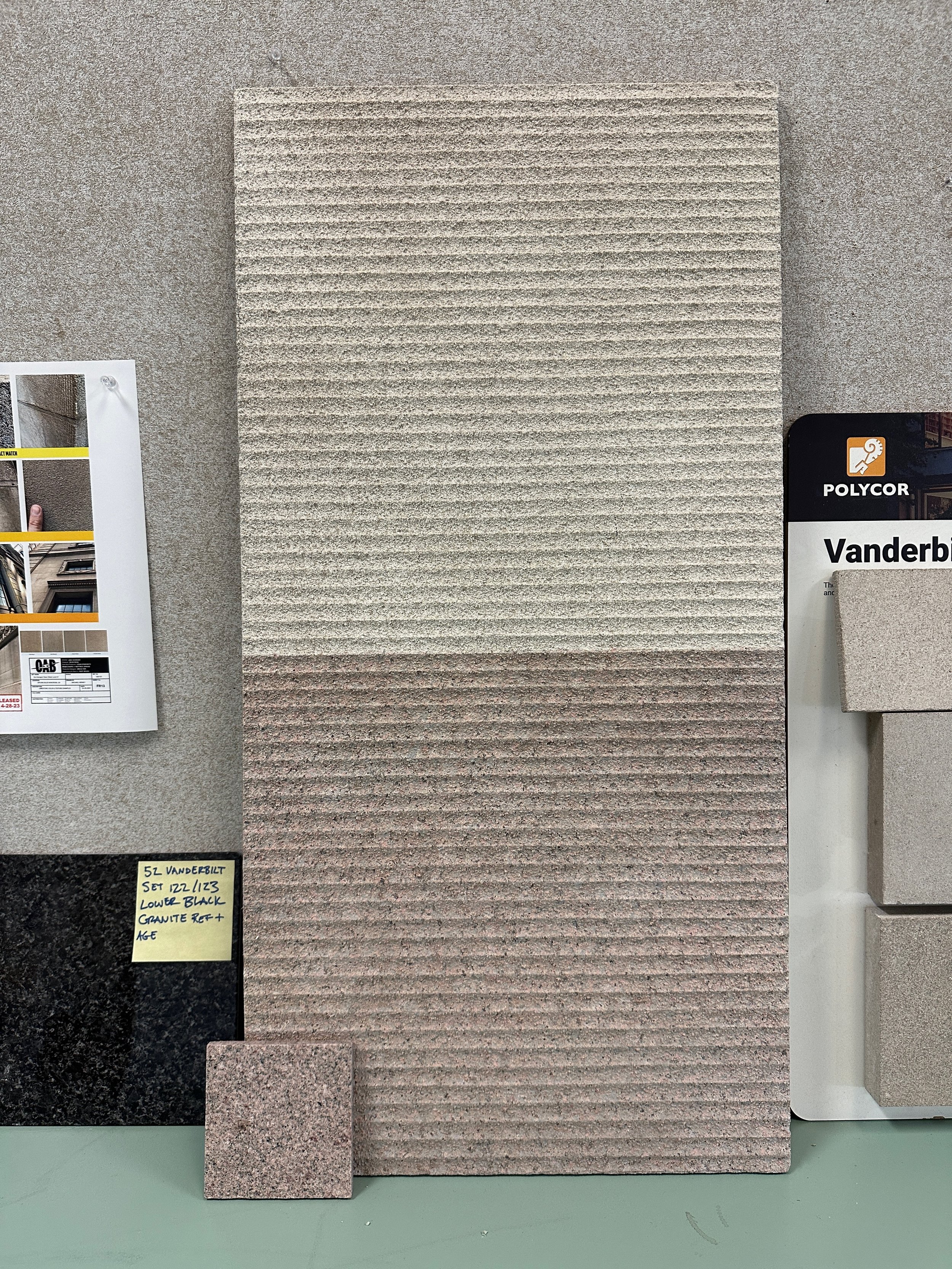 Sample beige brick veneer siding sample board and two small square brick samples on display at a home improvement store.