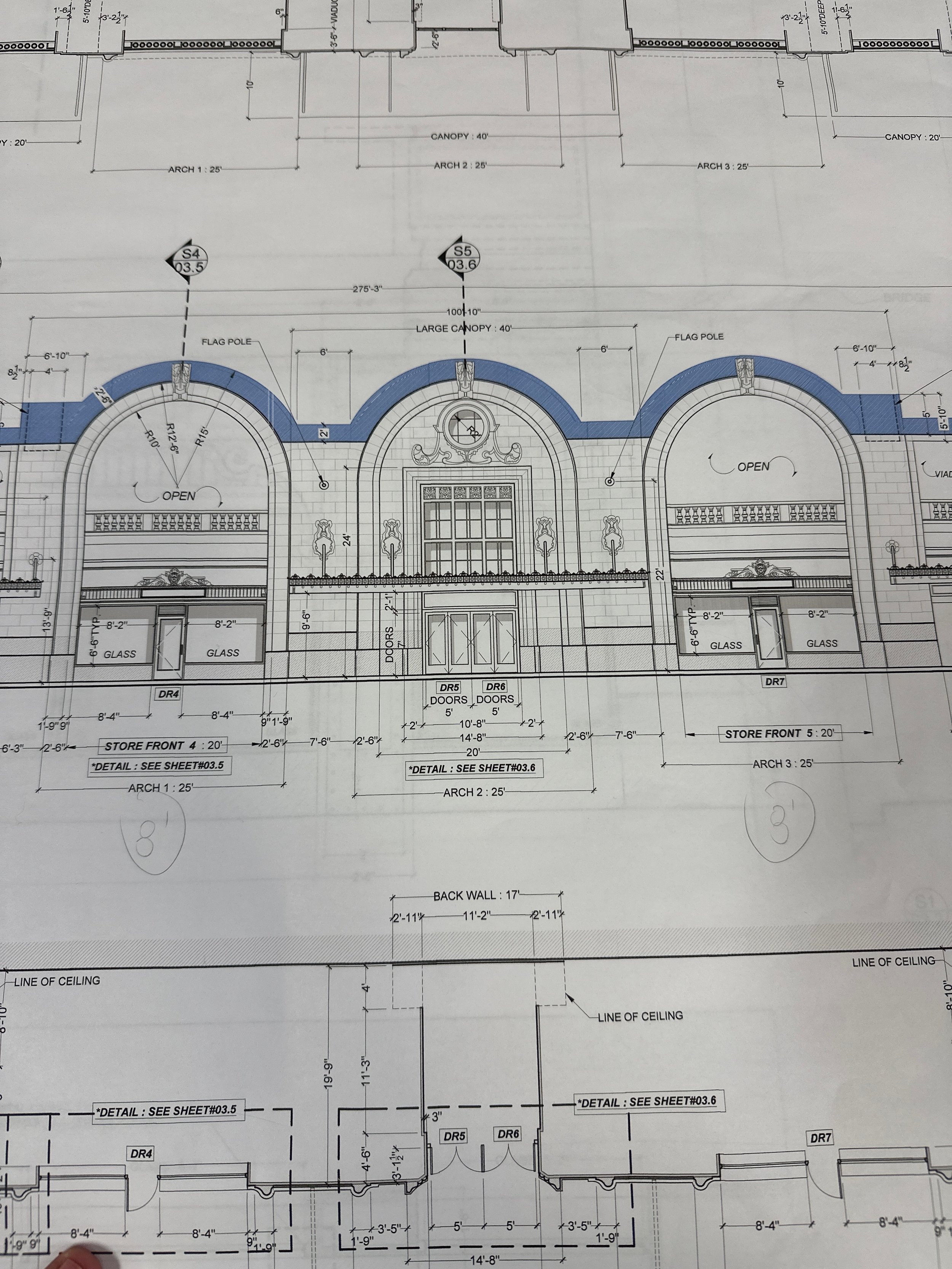 Architectural blueprints for a building facade featuring three arched sections with decorative details, doors, and large windows, with measurements and construction notes.