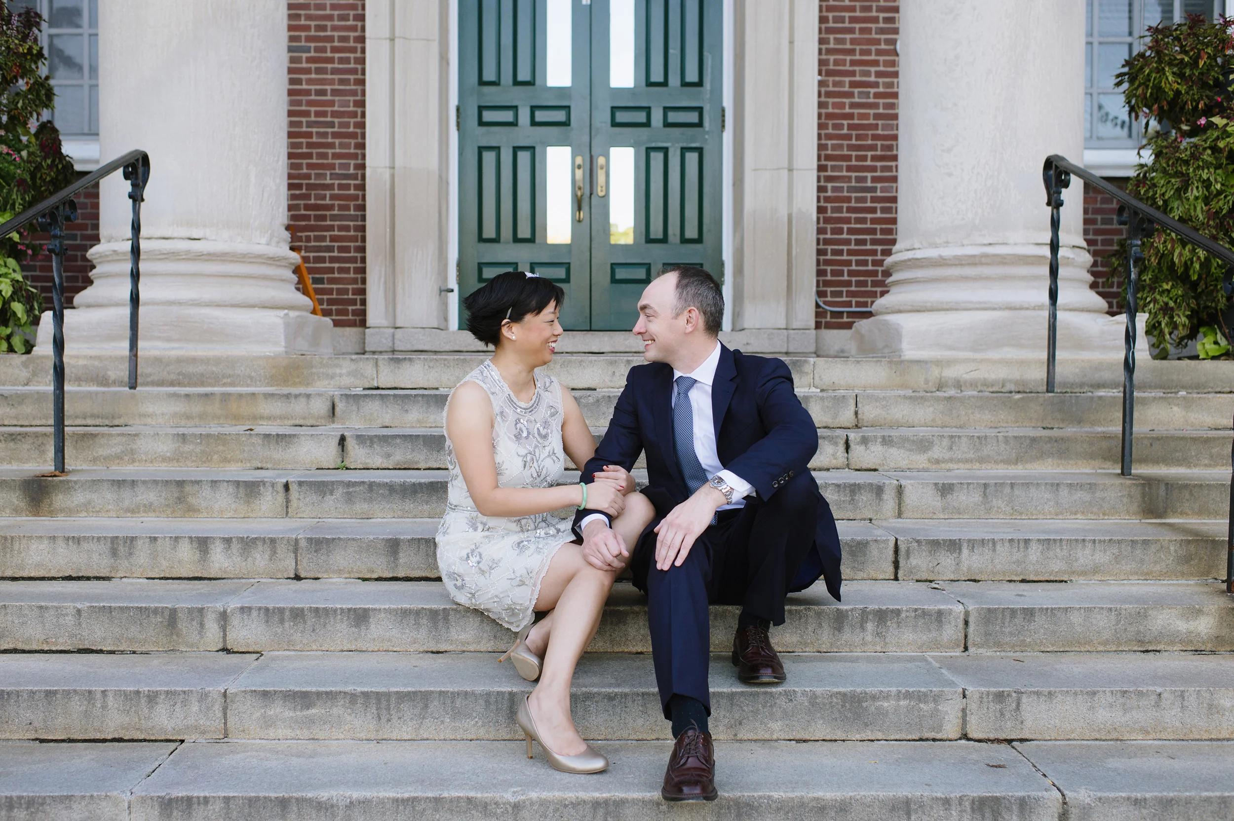 Bride and groom sitting on steps of Newton Town Hall