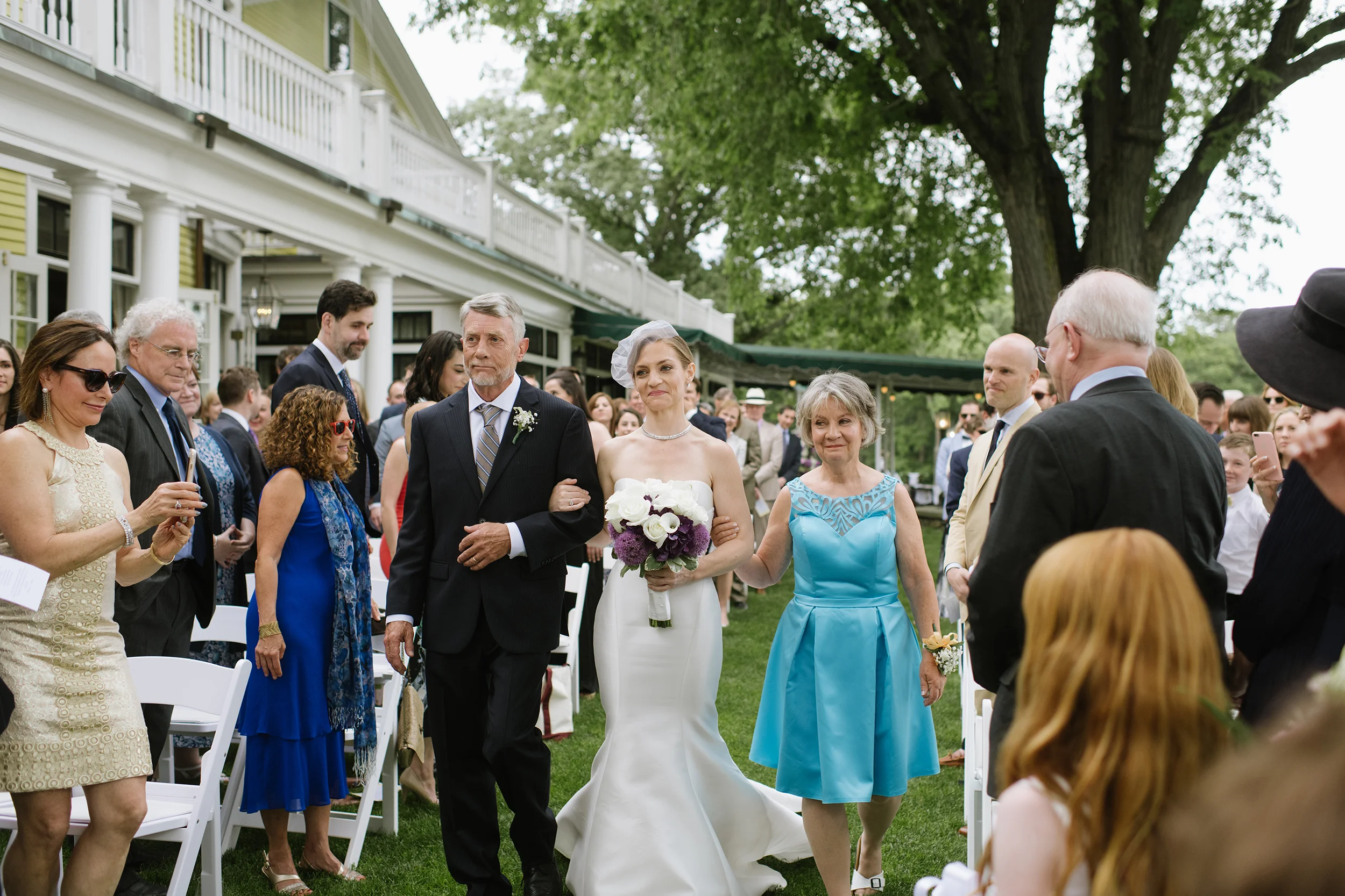 Bride walking down the aisle at The Country Club, Brookline with her parents