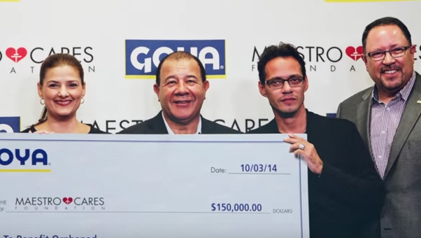 Mark Anthony and his Maestro Cares partner Henry Cardenas accept a check from Goya president Bob Unanue.