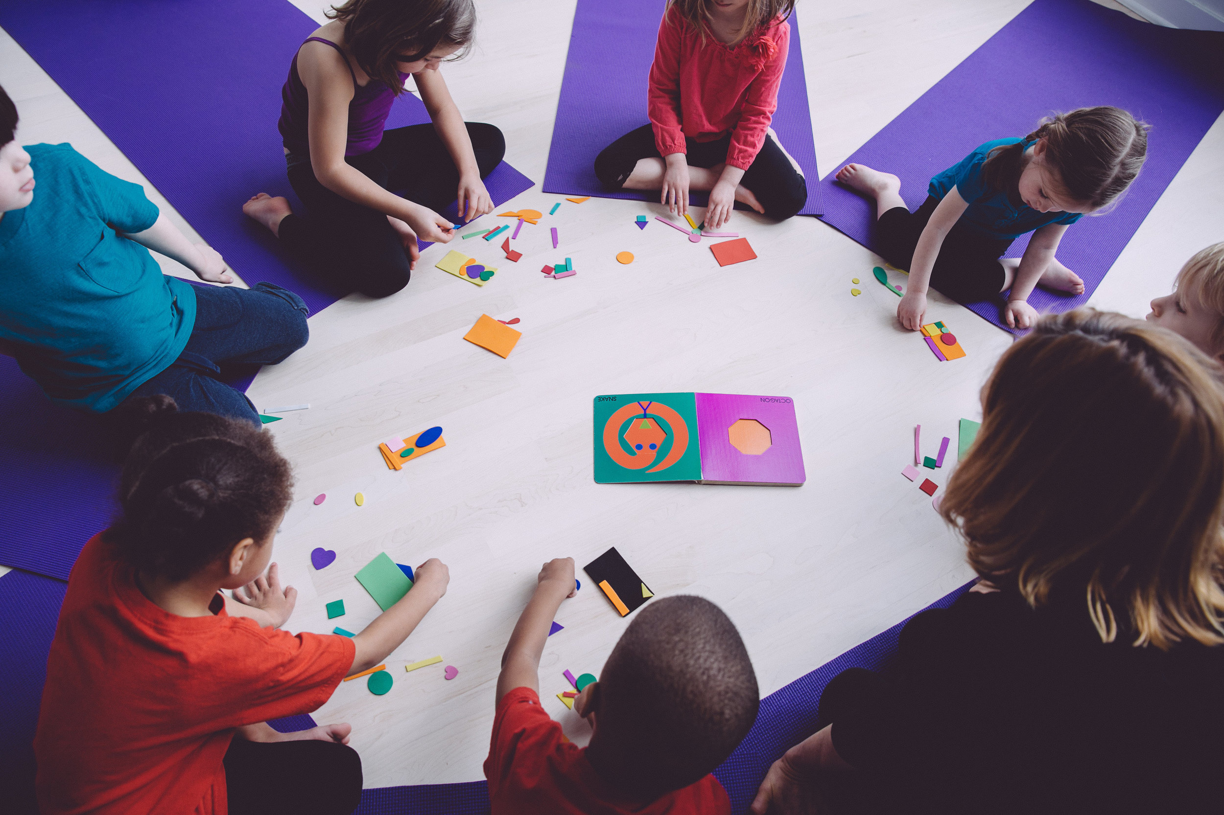 Pre-school children enjoying a geometric visual art project inspired by Lois Ehlert's book "Color Zoo"