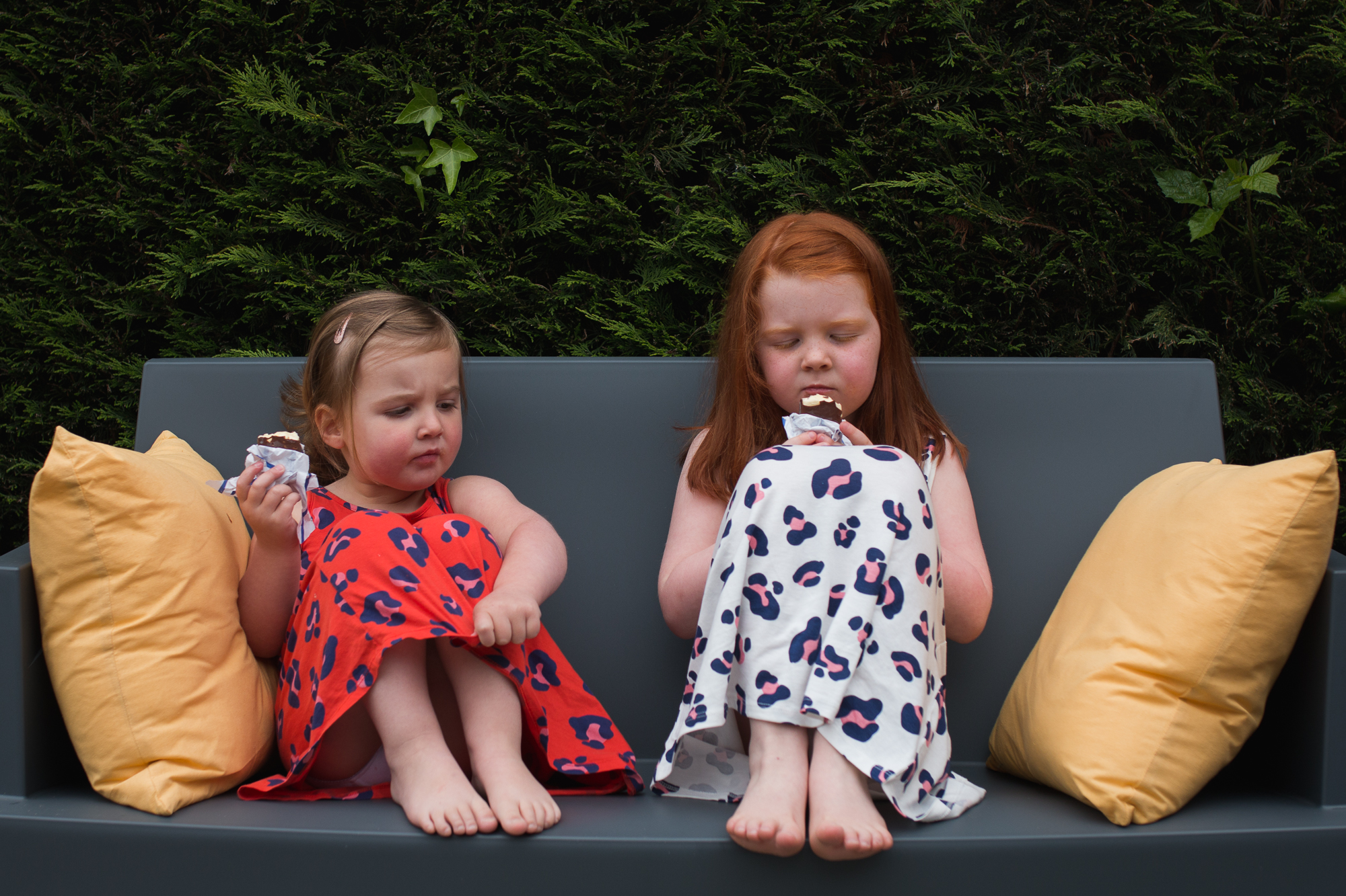 sisters on bench eating ice-cream