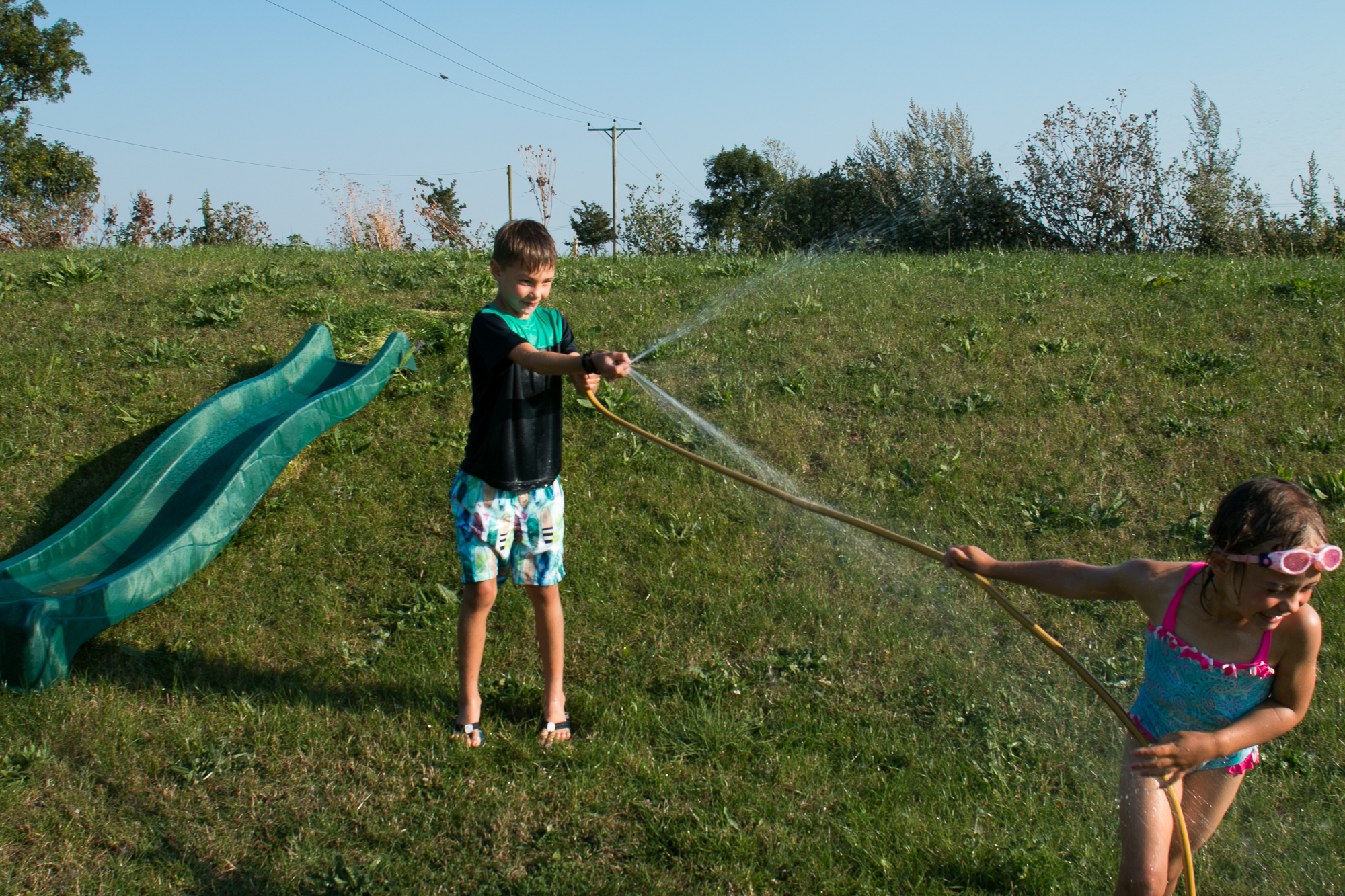 brother and sister having water fight