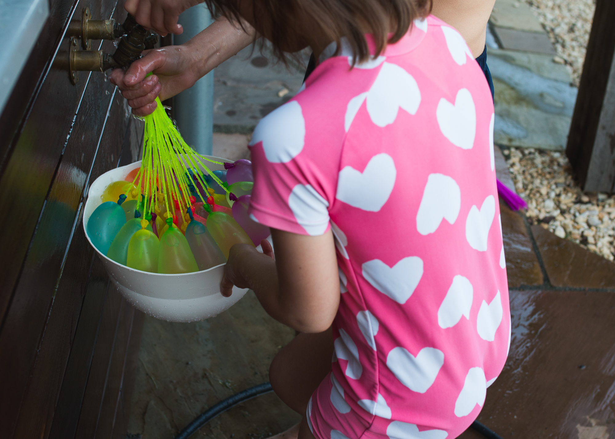 brother and sister filling up water balloons