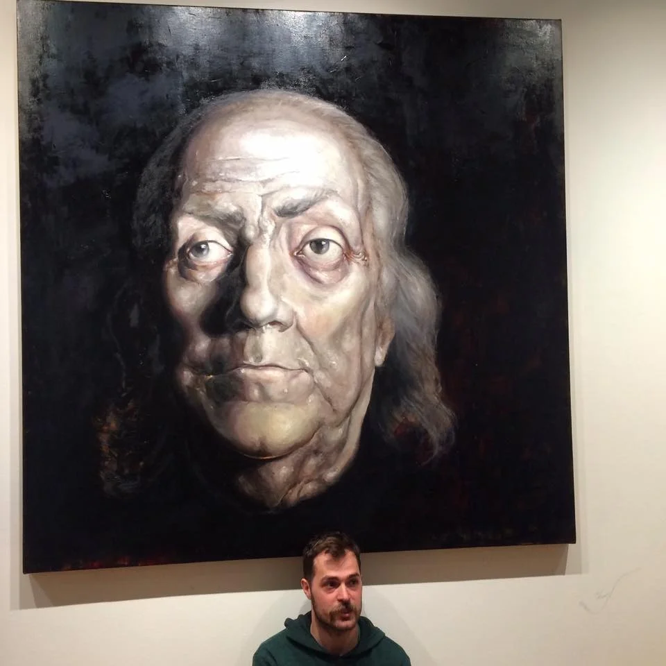 Artist, Jordan Lance Morgan in front of his painting "Rising and Setting"