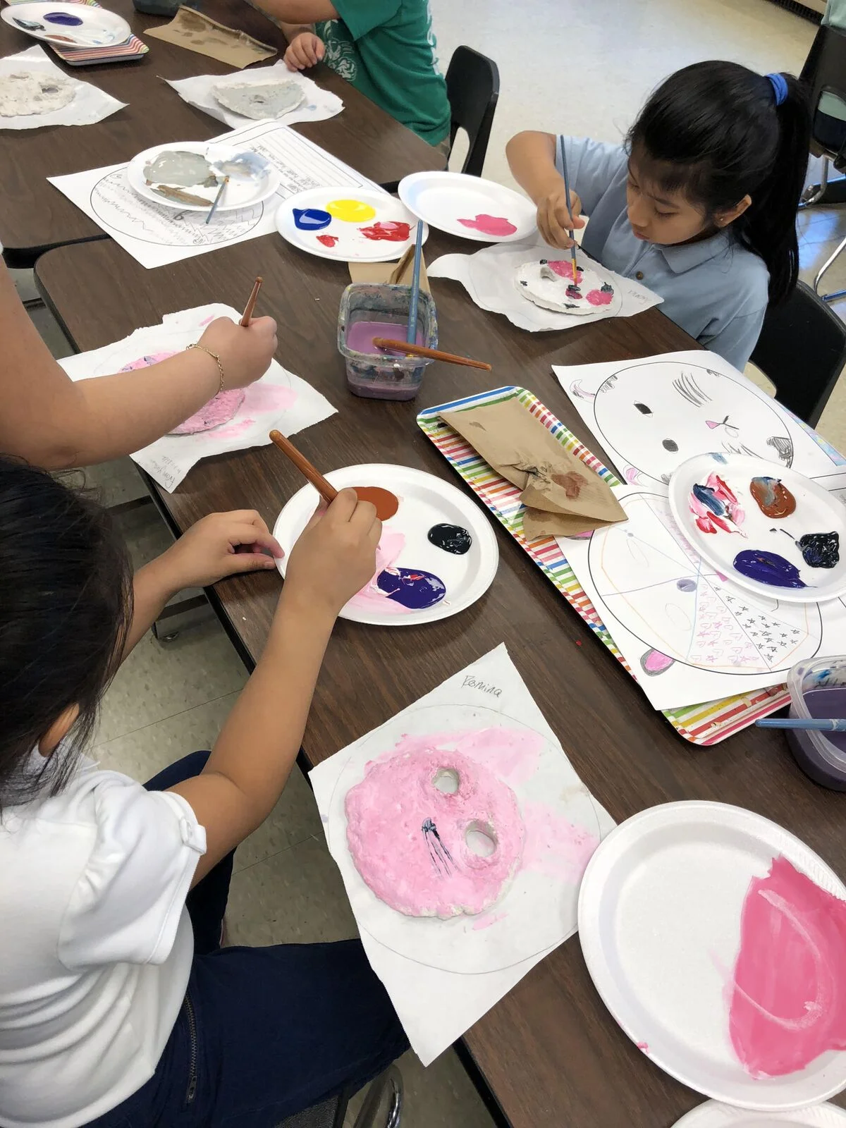 Third-grade students at Frayser Elementary enjoyed a mask-making project. Students read and discussed When Turtle Grew Feathers , a Choctaw Native American version of The Tortoise and the Hare . We then used CelluClay, a papier-mache goopy substance, to make the base of their masks. Basing our mask characters on North American animals in the Southeast U.S., we then designed our masks on paper and wrote a short statement about why they chose that animal. Then, to the painting and enhancement of the masks… We used paints, yarns, cut paper, raffia and feathers to add character, interest ferociousness, silliness and accuracy to our painted mask forms. Voila! The masks were sent home to live on the walls of the students’ homes.