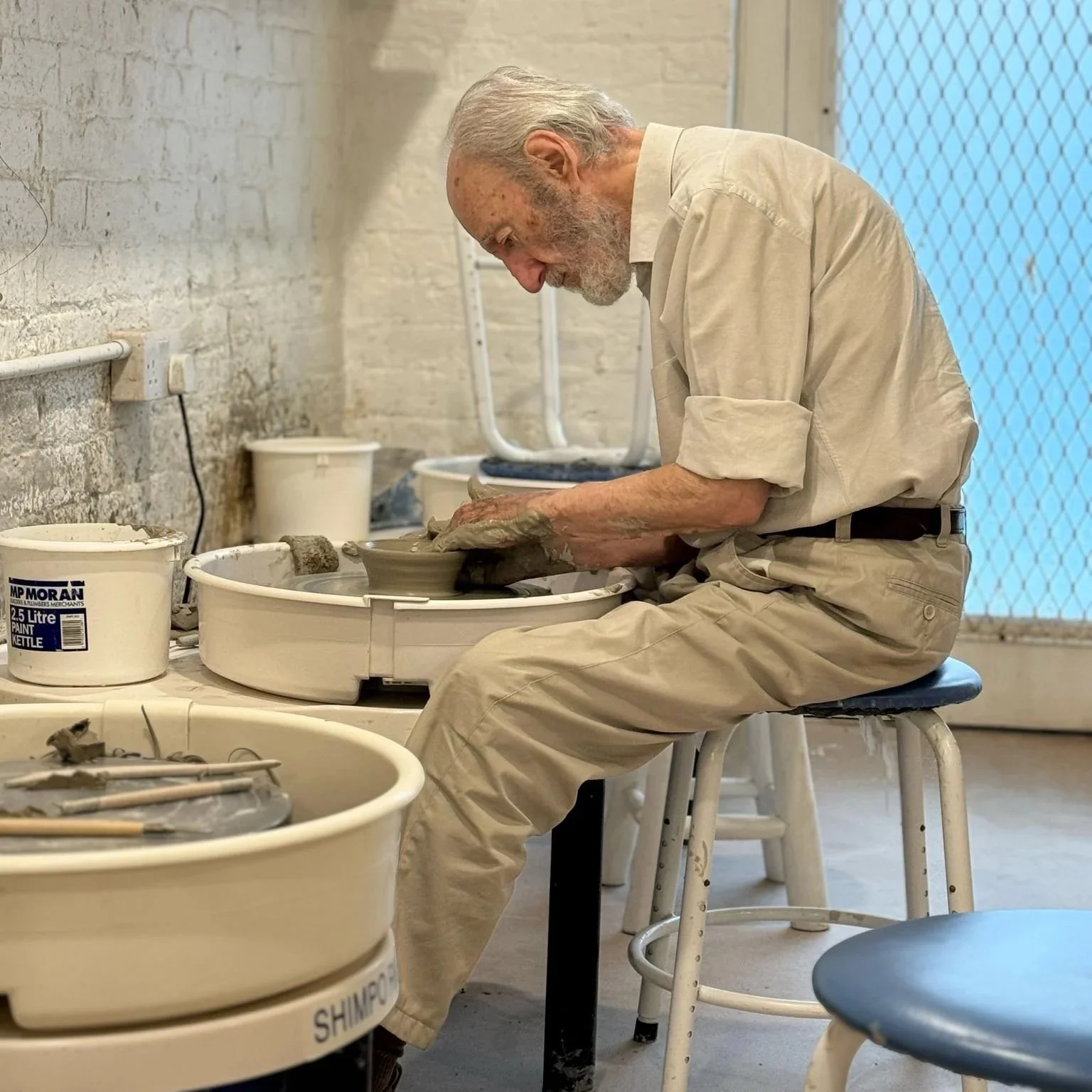 Elderly man working on the pottery wheel during a pottery class at Ceramics Sculpture Studio