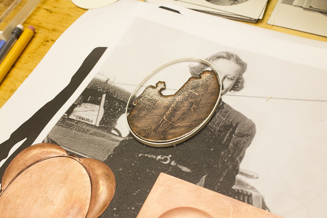 A brooch in progress with a photo of Barbara's mother in the background.