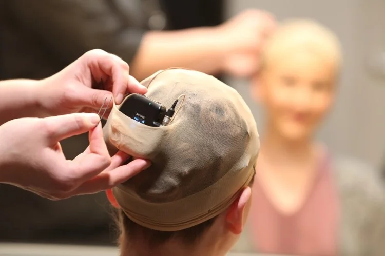 Shure ADX1M being mounted in a wig (c) Shure