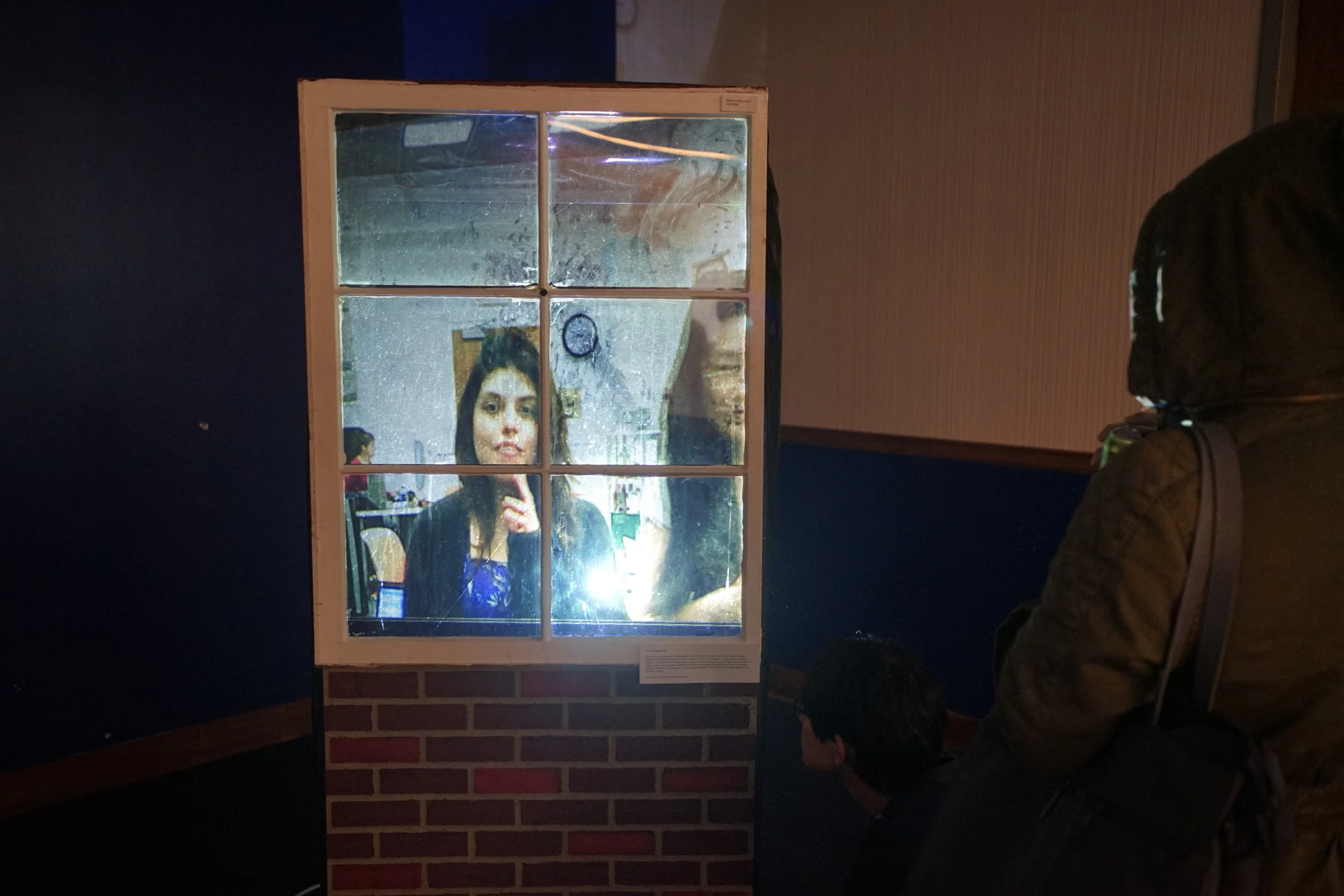 CHRIS MILLER - WINDOW TO THE PRESENT Interactive installation. Window to the Present uses raspberry pi technology to record videos of everyone who looks into the prop window. However, when new individuals come up to the window, there is a time lag and participants will see the reflections of those before them and not themselves. 