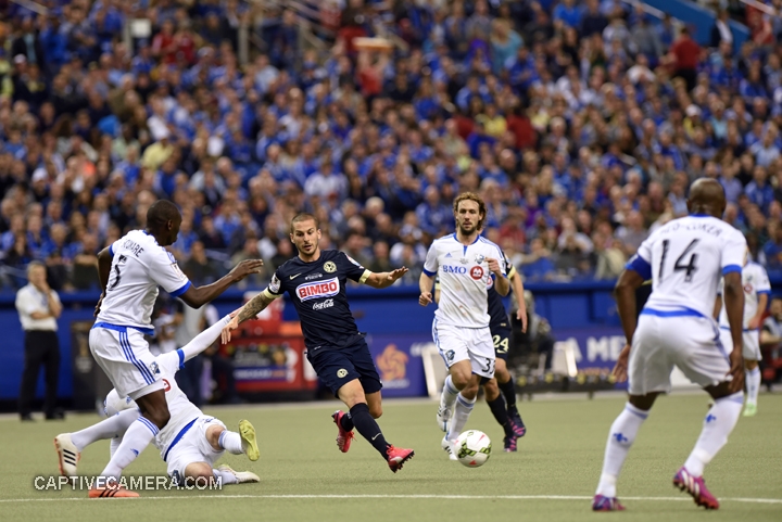   Montreal, Canada - April 29, 2015: Dario Benedetto #9 of Club America evades a tackle from Montreal Impact opposition.  