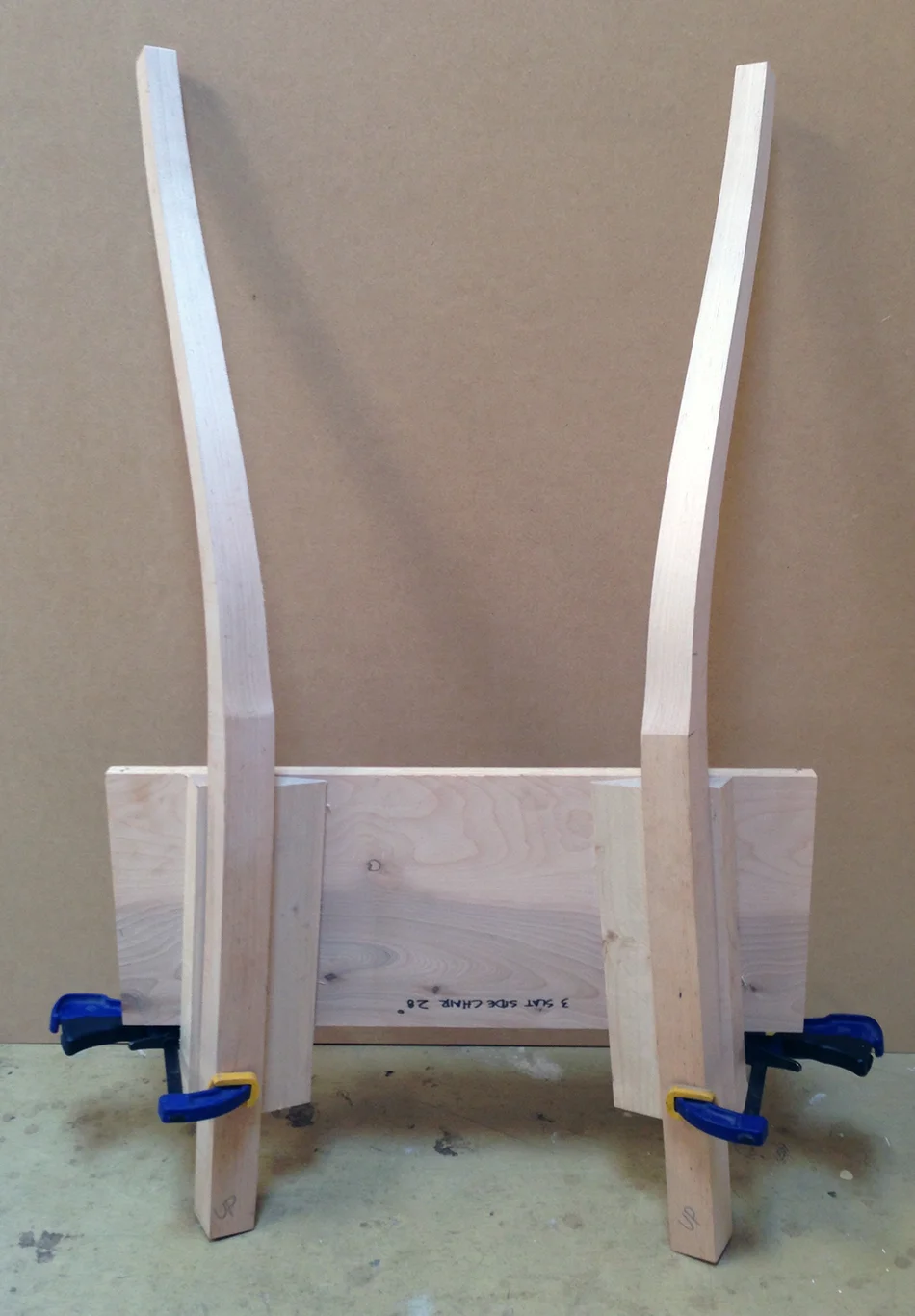 These rear legs are ready for slat mortising. The jig holds them in the same orientation they will appear in the final chair.