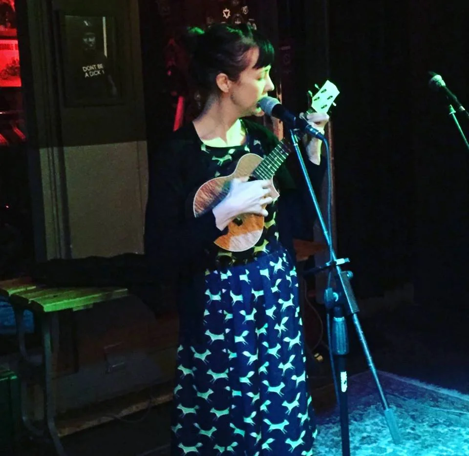 Me in a dress I made, playing at House of Machines in Cape Town at an open mic.