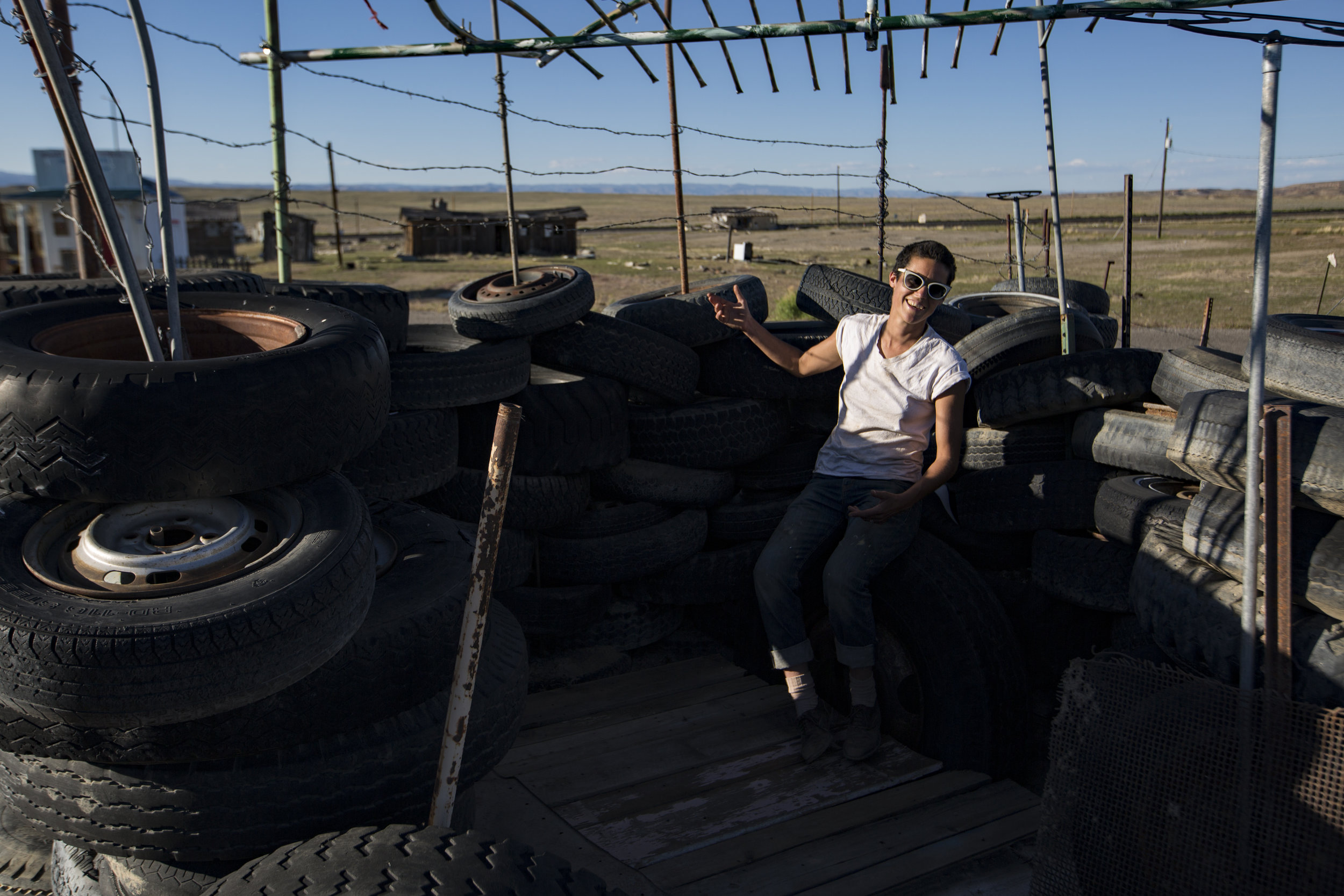  Eileen poses for a portrait inside her tire fort outside of one of her properties in Cisco, Utah. Eileen is restoring many of the old buildings and putting them on Airbnb for people to rent in the hopes of bringing the town back.&nbsp; 