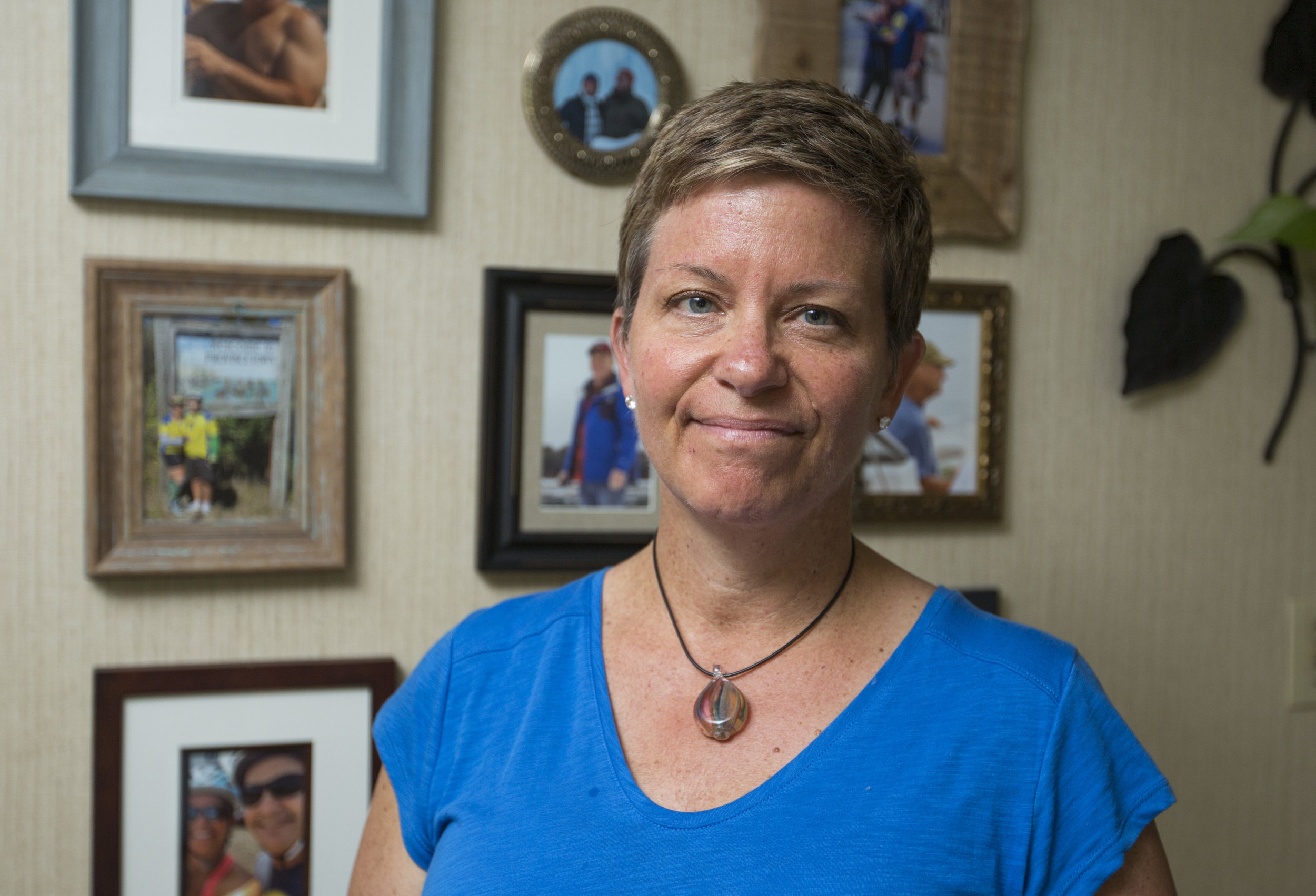  Tracey Hanna poses for a portrait in her home in front of a wall of images of her partner who passed away from the tick-borne disease the Powassan virus this winter. 