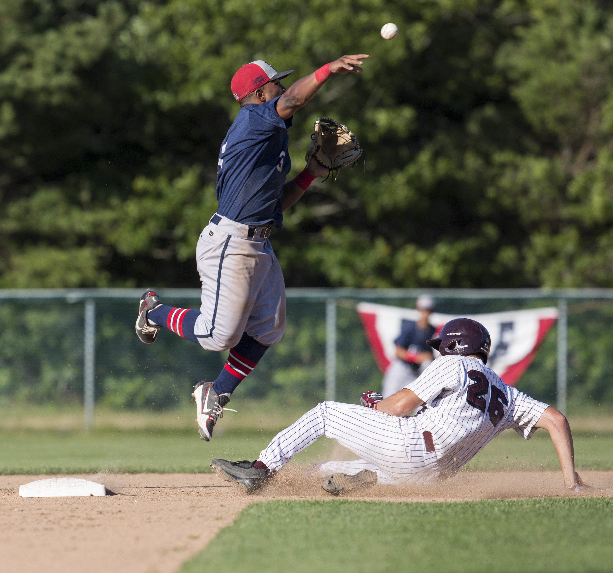  Cobie Vance, of the Harwich Mariners, jumps to catch the ball as Zack Kone, of the Cotuit Kettleers slides to second. Kone was called out during the game in Cotuit on July 9, 2017. 