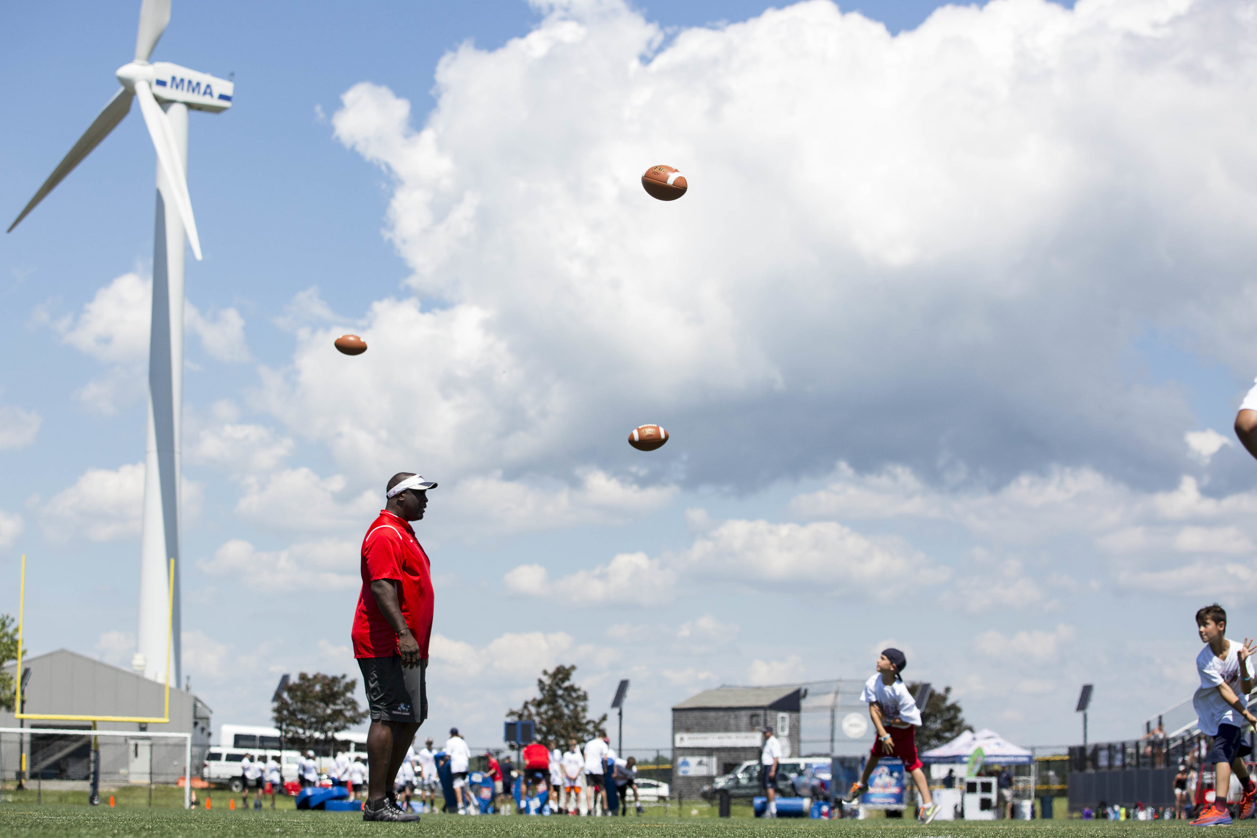  Balls fly over the head of former New England Patriots star Vernon Crawford during a passing drill a the Football for YOU clinic held at Massachusetts Maritime Academy on July 10, 2017. 