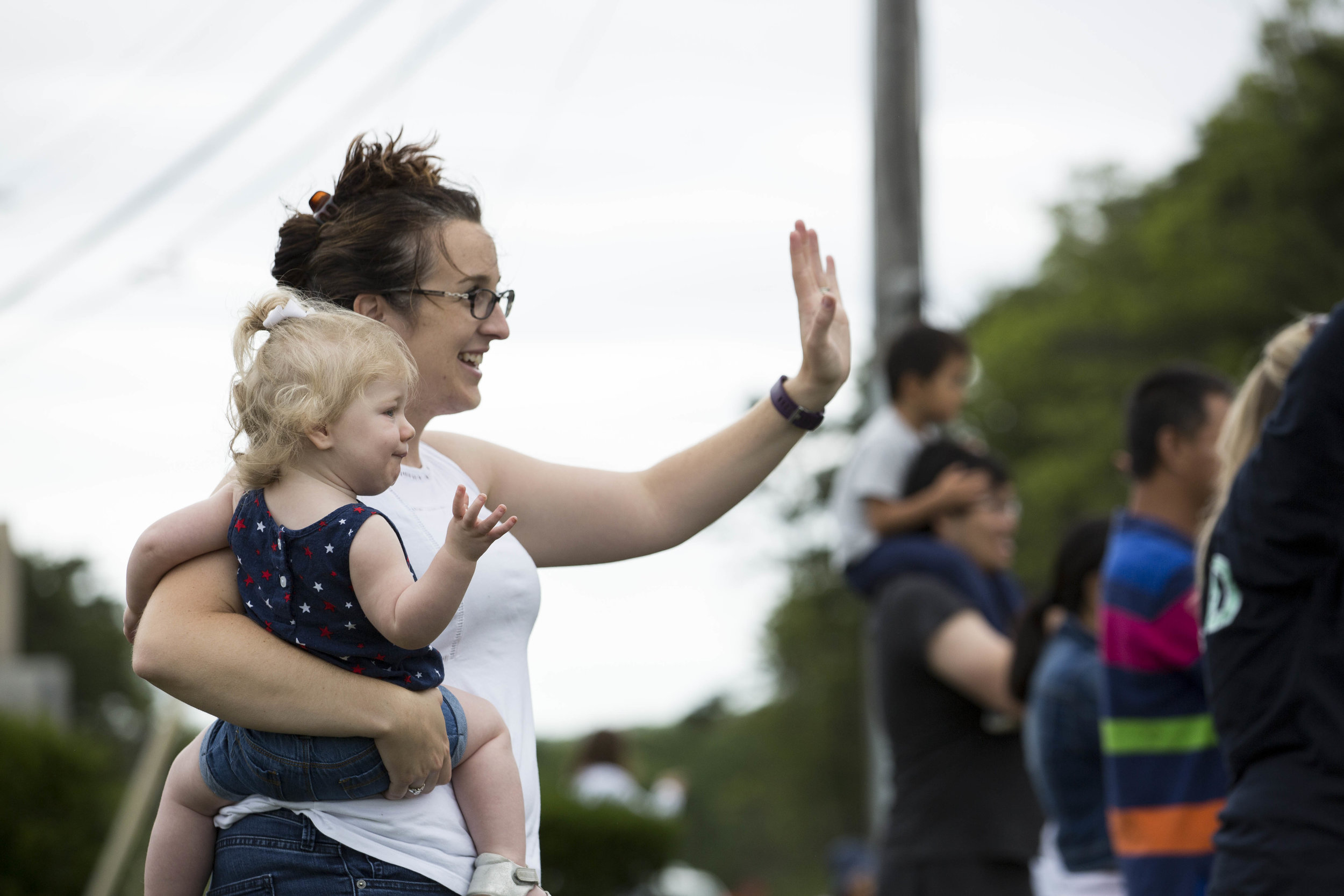  Erin Cunha holds her daughter Laurel while they wave to people on motorcycles coming around the Bourne Rotary heading onto MacAuthur Blvd during Big Nick's Ride for the Fallen on July 23, 2017. 
